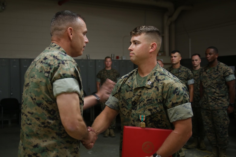 Brig. Gen. Matthew Glavy issues the Navy and Marine Corps Achievment Medal to Capt. Seve Aguinaga aboard Marine Corps Air Station Beaufort, S.C., Oct. 14, 2016. Glavy visited the air station to assess the effects of Hurricane Matthew and attend the Marine Fighter Attack Squadron 122 change of command ceremony. Glavy commended all the Marines there for their tremendous efforts in preparing and responding to the storm, noting they “were fighting outside of their weight class” after conducting operations normally expected of larger support squadrons to minimize impacts of the hurricane. Aguinaga is the combat engineer officer with Marine Wing Support Detachment 31. (U.S. Marine Corps photos by Lance Cpl. Mackenzie Gibson/Released)