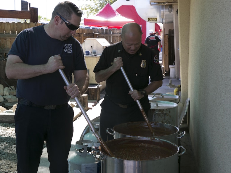 Tony Marchisio, fire inspector and Avlin Arita, assistant chief fire prevention, Combat Center Fire Department stir chili for the Fire Prevention Chili Luncheon at the Fire Station aboard the Marine Corps Air Ground Combat Center, Twentynine Palms, Calif., Oct. 12, 2016. (Official Marine Corps photo by Lance Cpl. Dave Flores/Released)