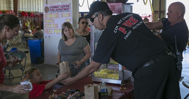 Kevin Mathieu, assistant chief of operations, Combat Center Fire Department, passes out popcorn to patrons of the base during the Fire Prevention Chili Luncheon at the Fire Station aboard the Marine Corps Air Ground Combat Center, Twentynine Palms, Calif., Oct. 12, 2016. (Official Marine Corps photo by Lance Cpl. Dave Flores/Released)