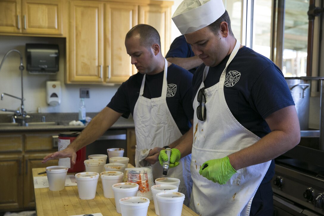 Gino Suarez and Paul Messer, firefighters, Combat Center Fire Department prepare the servings of chili for the Fire Prevention Chili Luncheon at the Fire Department aboard the Marine Corps Air Ground Combat Center, Twentynine Palms, Calif., Oct. 12, 2016. (Official Marine Corps photo by Lance Cpl. Dave Flores/Released)