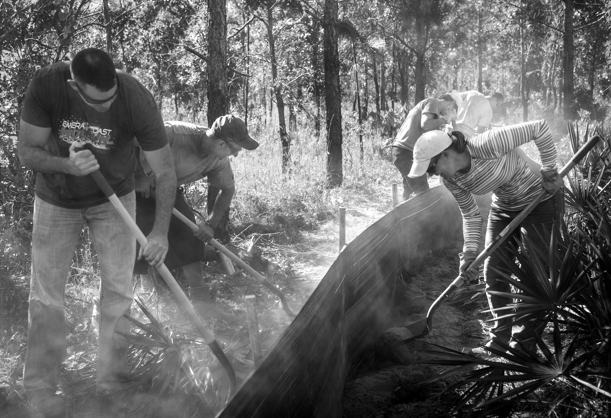 A group of natural resources personnel and volunteers fill in dirt around a silt fence on the Eglin Air Force Base range Oct. 13.  The fencing will surround a new habitat for approximately 250 gopher tortoises.  The tortoises are being relocated from South Florida to Eglin escaping certain death from urban development.  Approximately 500 gopher tortoises will eventually be moved to the range.  (U.S. Air Force photo/Samuel King Jr.)