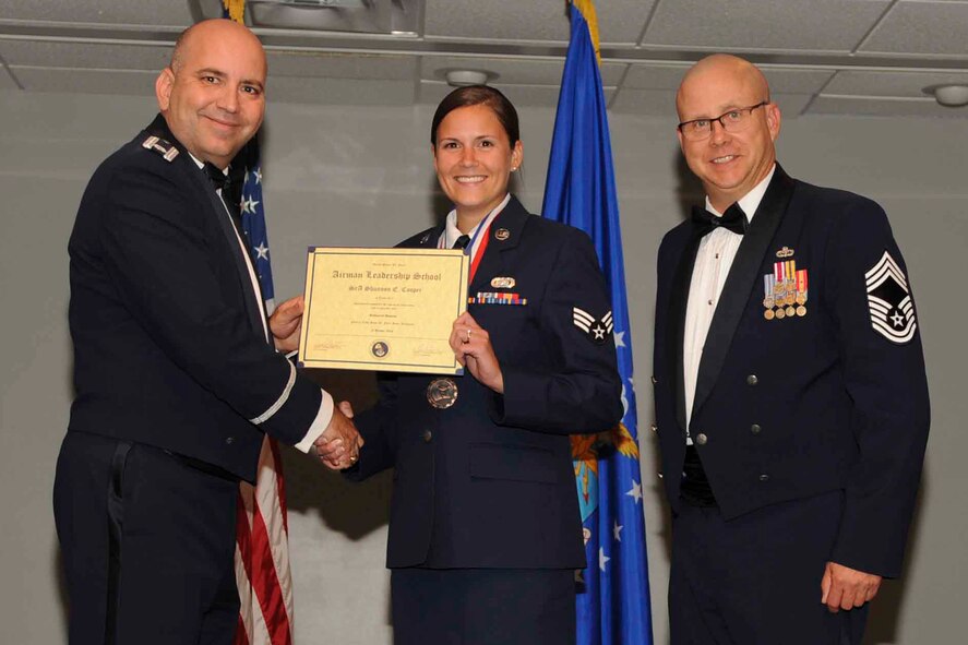 U.S. Air Force Reserve Lt. Col. Paul Centinaro, commander of the 913th Maintenance Squadron, Senior Airman Shannon Cooper, a personalist assigned to the 913th Operations Support Squadron and Chief Master Sgt. Paul Stewart, the superintendent for the 913th Airlift Group, pose for a photo during the Airman Leadership School (ALS) graduation ceremony at Little Rock Air Force Base, Ark., Oct. 13, 2016. ALS is an Air Force education program held at base level to prepare senior Airmen for positions of greater responsibility. The course teaches leadership skills required of supervisors and reporting officials throughout the Air Force. (U.S. Air Force photo by Senior Airman Stephanie Serrano)