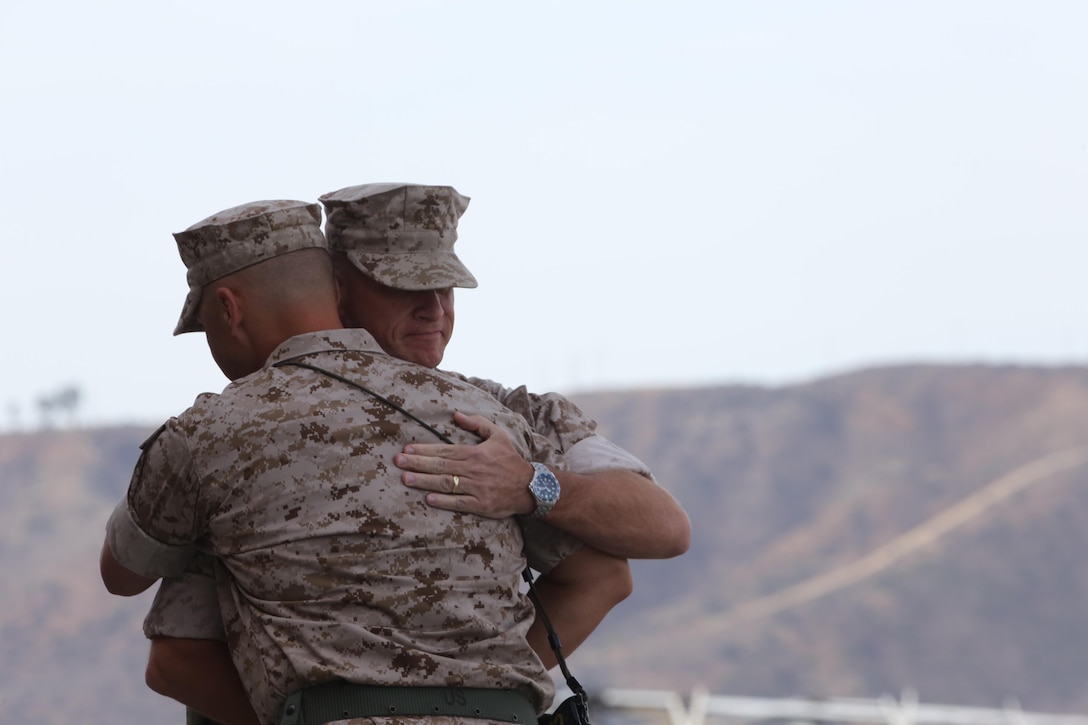 Lt. Col. Paul Kopacz, left,  former commanding officer of Marine Medium Tiltrotor Squadron (VMM) 364, hugs Lt. Col. Stephen Conley, commanding officer for VMM-364, during their change of command aboard Marine Corps Air Station Camp Pendleton, Calif., Oct. 6. Kopacz and Conley have been friends since their sophomore year of high school and now, 26 years later, Conley has taken command of VMM-364 from Kopacz. (U.S. Marine Corps photo by Lance Cpl. Jake M.T. McClung/Released)