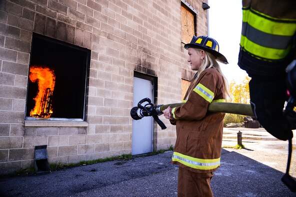 Hill Field Elementary School Firefighter-for-a-Day Sarah Cunieo prepares to extinguish a simulated structure fire Oct. 13 at Hill Air Force Base. Four Hill Field Elementary School students spent the day with the Hill Air Force Base Fire Department after winning an essay contest. (U.S. Air Force photo by R. Nial Bradshaw)