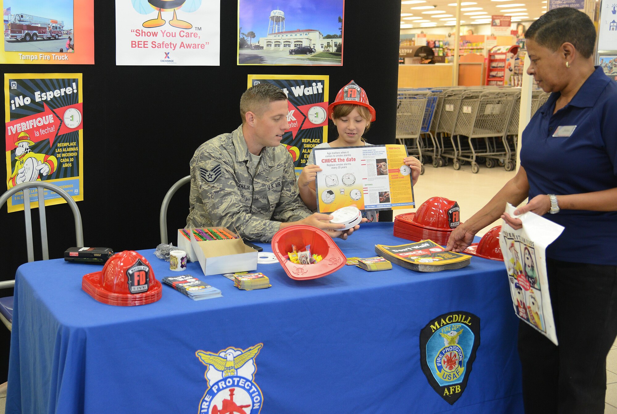 Staff Sgt. Casey Stanaland, a crew chief with the 6th Maintenance Squadron, teaches fire detector inspection to Evelyn Sirvent, a loss prevention assistant with the Army and Air Force Exchange Service, in the Base Exchange at MacDill Air Force Base, Fla., Oct. 13, 2016. Members of Team MacDill instructed people on how to inspect a fire detector for any malfunctions. 