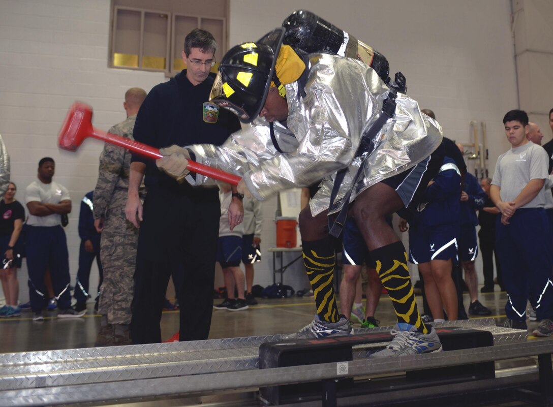 Senior Airman Alexander Buchanan, an aviation resource management journeyman assigned to the 37th Bomb Squadron, participates in a kaiser sled obstacle during the Firefighter Challenge at Ellsworth Air Force Base, S.D., Oct. 7, 2016. The Kaiser Sled obstacle uses a sledge hammer to simulate chopping a roof with an axe. (U.S. Air Force photo by Airman 1st Class Donald C. Knechtel)