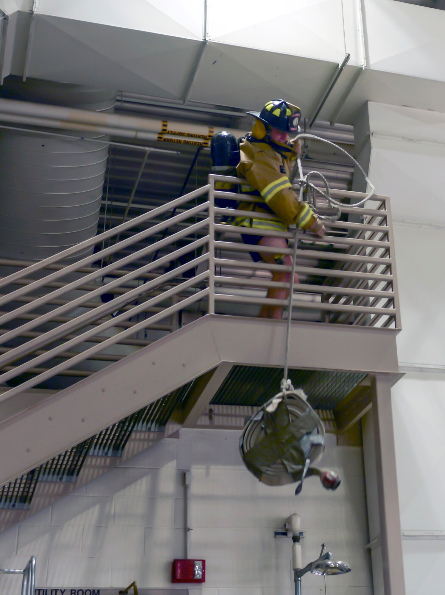 Airman 1st Class Parker Davis, an explosive ordinance disposal apprentice assigned to the 28th Civil Engineer Squadron, performs a hose raise during the Firefighter Challenge at Ellsworth Air Force Base, S.D., Oct. 7, 2016. The hose raise involved lifting a rolled section of hose up to the mezzanine using a rope to simulate hauling tools and equipment up to a roof. (U.S. Air Force photo by Airman 1st Class Donald C. Knechtel) 