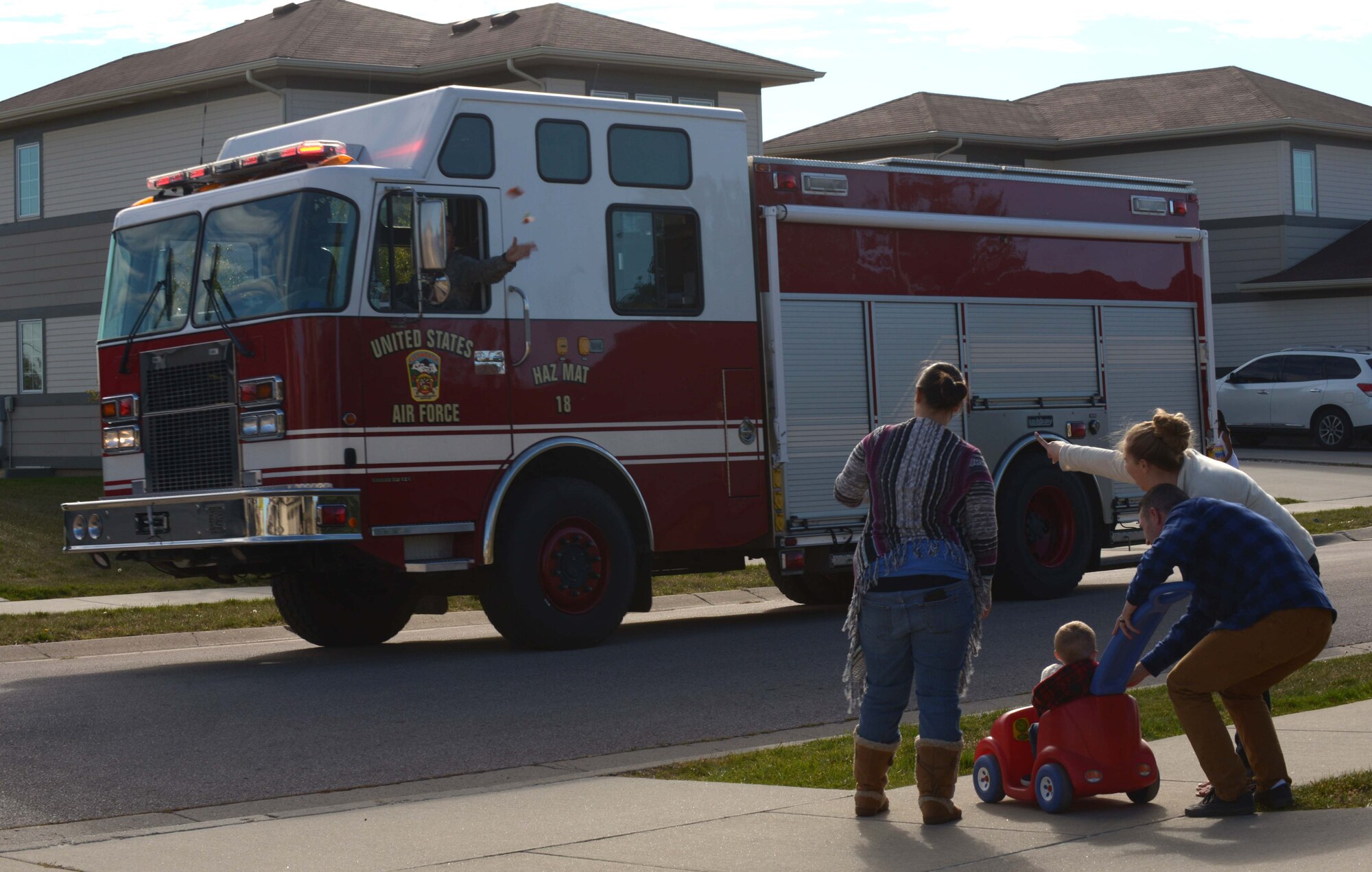 Families watch as trucks from the Ellsworth Fire Department drive through base housing during the Fire Prevention Week parade at Ellsworth Air Force Base, S.D., Oct. 8, 2016. The goal of the parade was to bring awareness to Fire Prevention Week and promote the importance of fire safety for all base personnel and their families. (U.S. Air Force photo by Airman 1st Class Donald C. Knechtel)