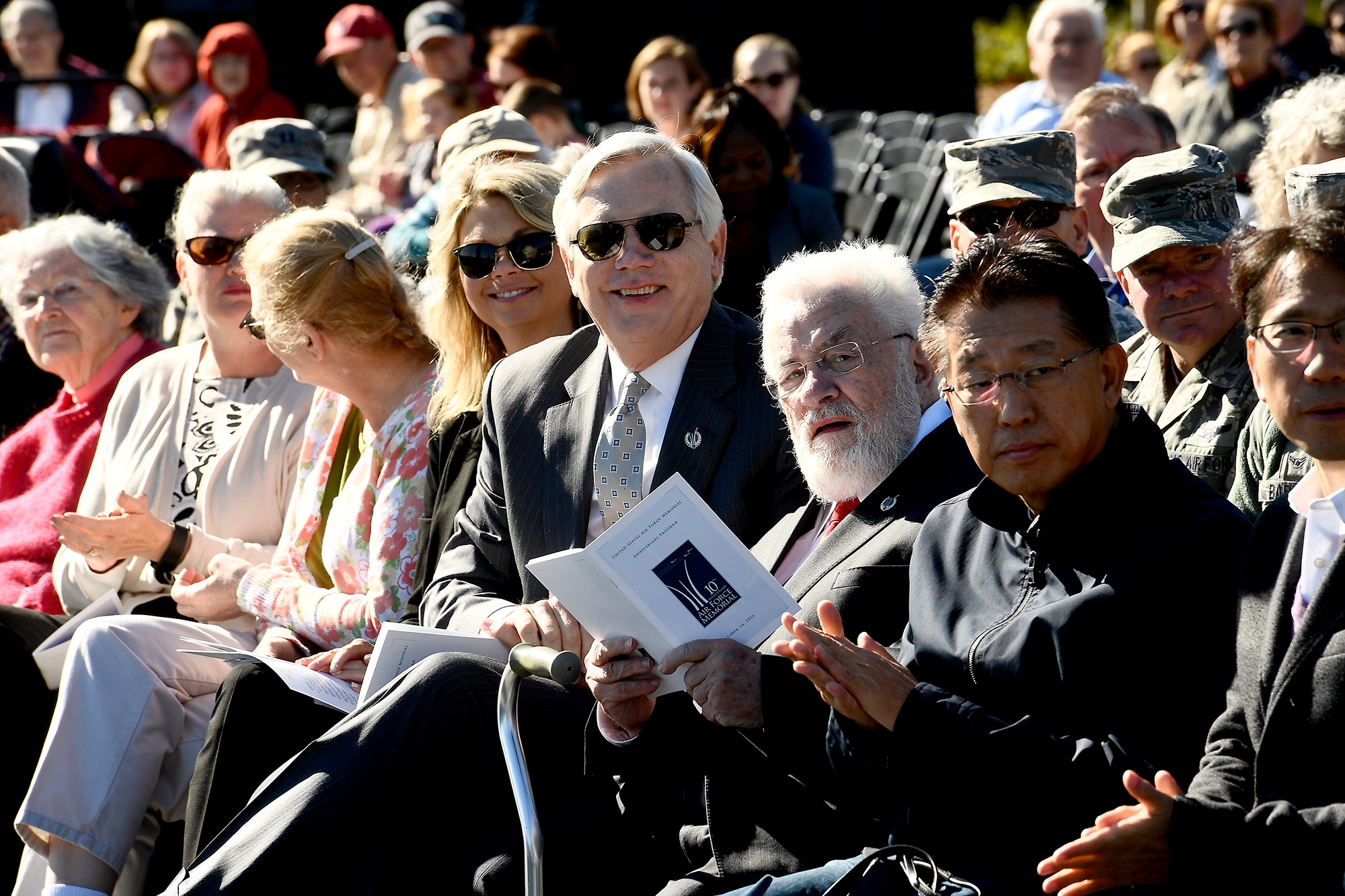 Adrian Cronauer, a Vietnam-era Air Force disc jockey, references the event program during the Air Force Memorial's 10th anniversary ceremony in Arlington, Va., Oct. 14, 2016. (U.S. Air Force photo/Scott M. Ash)