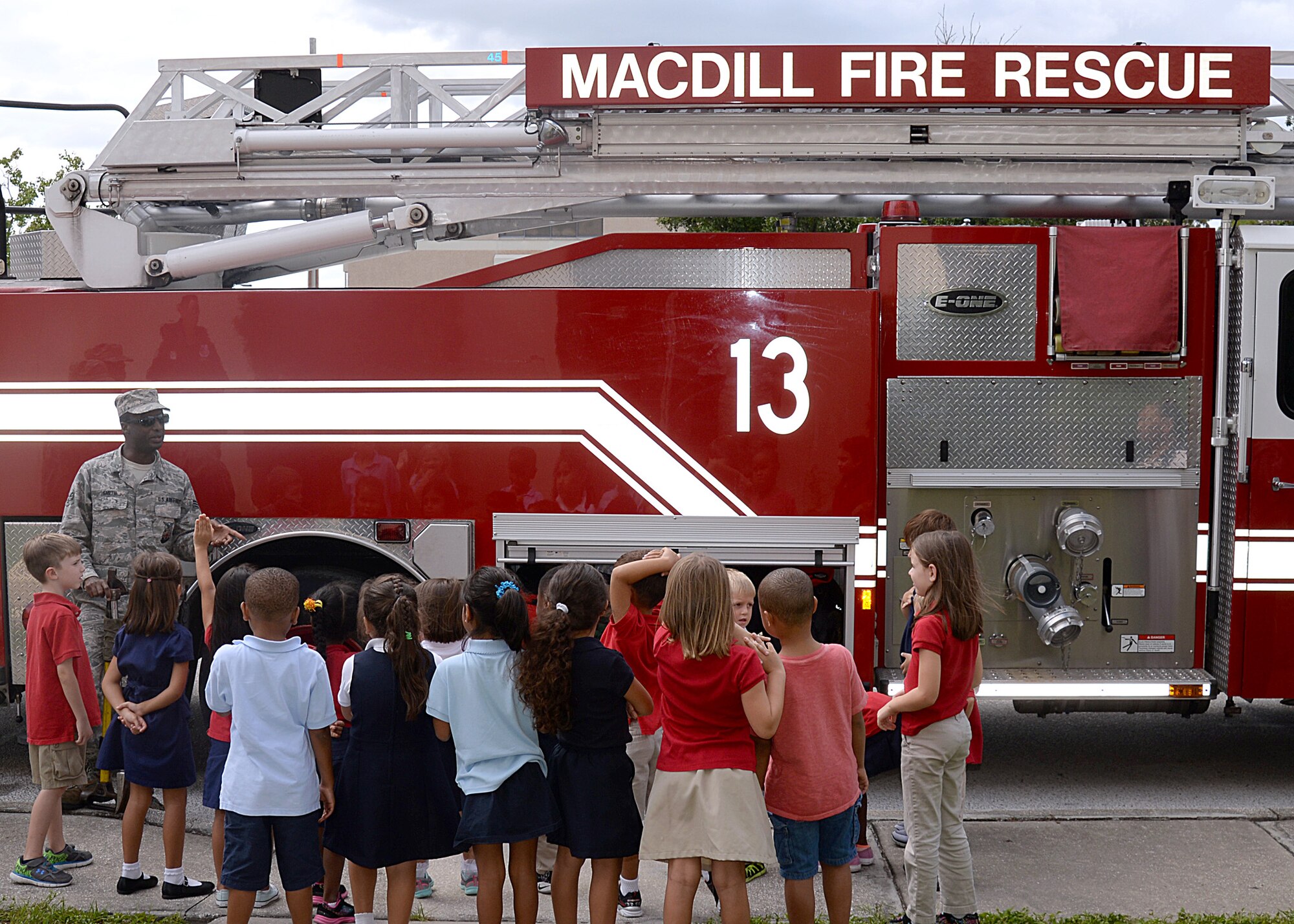 Senior Airman Khristopher Smith, a firefighter assigned to the 6th Civil Engineer Squadron, visits children at the school-age program during Fire Prevention Week at MacDill Air Force Base, Fla., Oct. 12, 2016. Throughout the week, firefighters also visited work centers around the base, Tinker K-8 School, the Child Development Centers and base housing. (U.S. Air Force photo by Staff Sgt. Brittany Liddon)