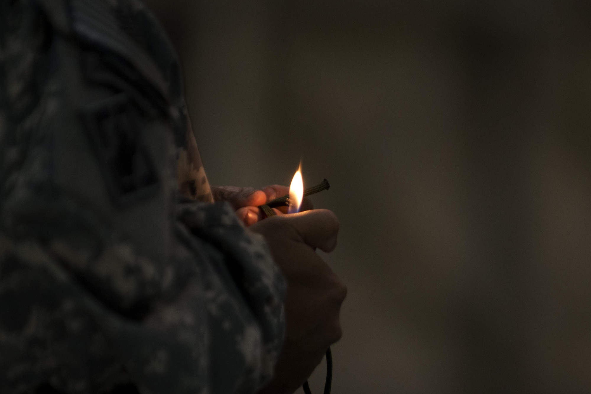 A paratrooper with the 4th Infantry Brigade Combat Team (Airborne), 25th Infantry Division, U.S. Army Alaska, burns the ends of his laces before boarding a Royal New Zealand Air Force C-130 Hercules for a jump during Red-Flag Alaska 17-1 at Joint Base Elmendorf-Richardson, Alaska, Oct. 12, 2016. Red-Flag Alaska 17-1 provides joint offensive counter-air, interdiction, close air support, and large force employment training in a simulated combat environment. 