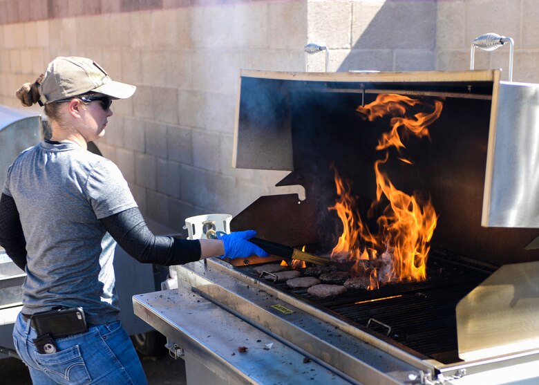 Staff Sgt. Chelsae, a non-commissioned officer in charge of the 314th Fighter Squadron, grills a batch of burgers during the New Mexico Aviation Aerospace Association Career Expo on Oct. 6, 2016 at Holloman Air Force Base, N.M. Food and drinks were available to students and guests of the event. (Last names are being withheld due to operational requirements. U.S. Air Force photo by Arlan Ponder)
