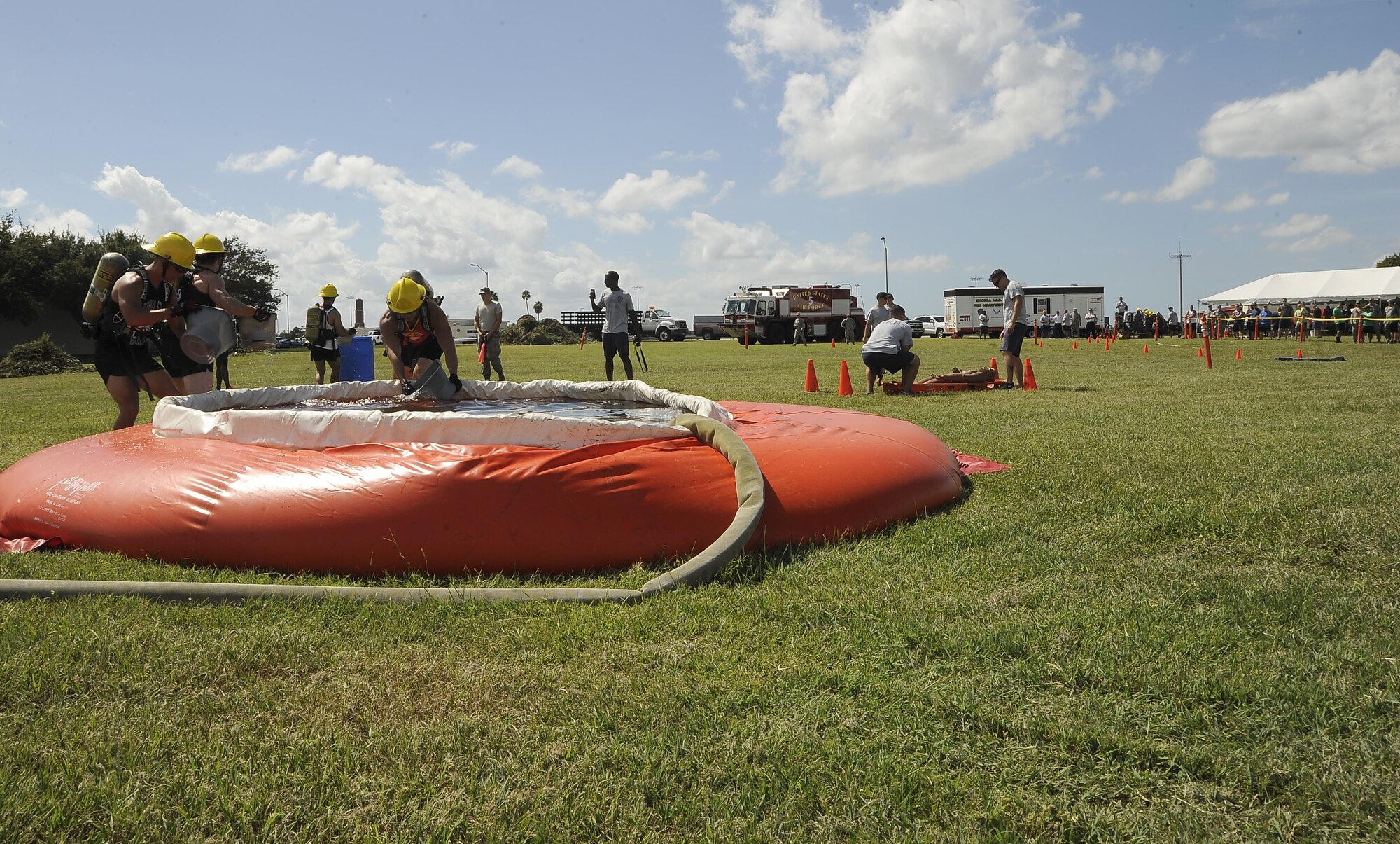 A participating team uses buckets to fill a container with water at the bucket brigade station during the MacDill’s Inaugural Firefighter’s Challenge at MacDill Air Force Base, Fla., Oct. 14, 2016. This challenge included nine different stations with one being a bonus station, where participates pulled a vehicle with rope. (U.S. Air Force photo by Airman 1st Class Mariette Adams)