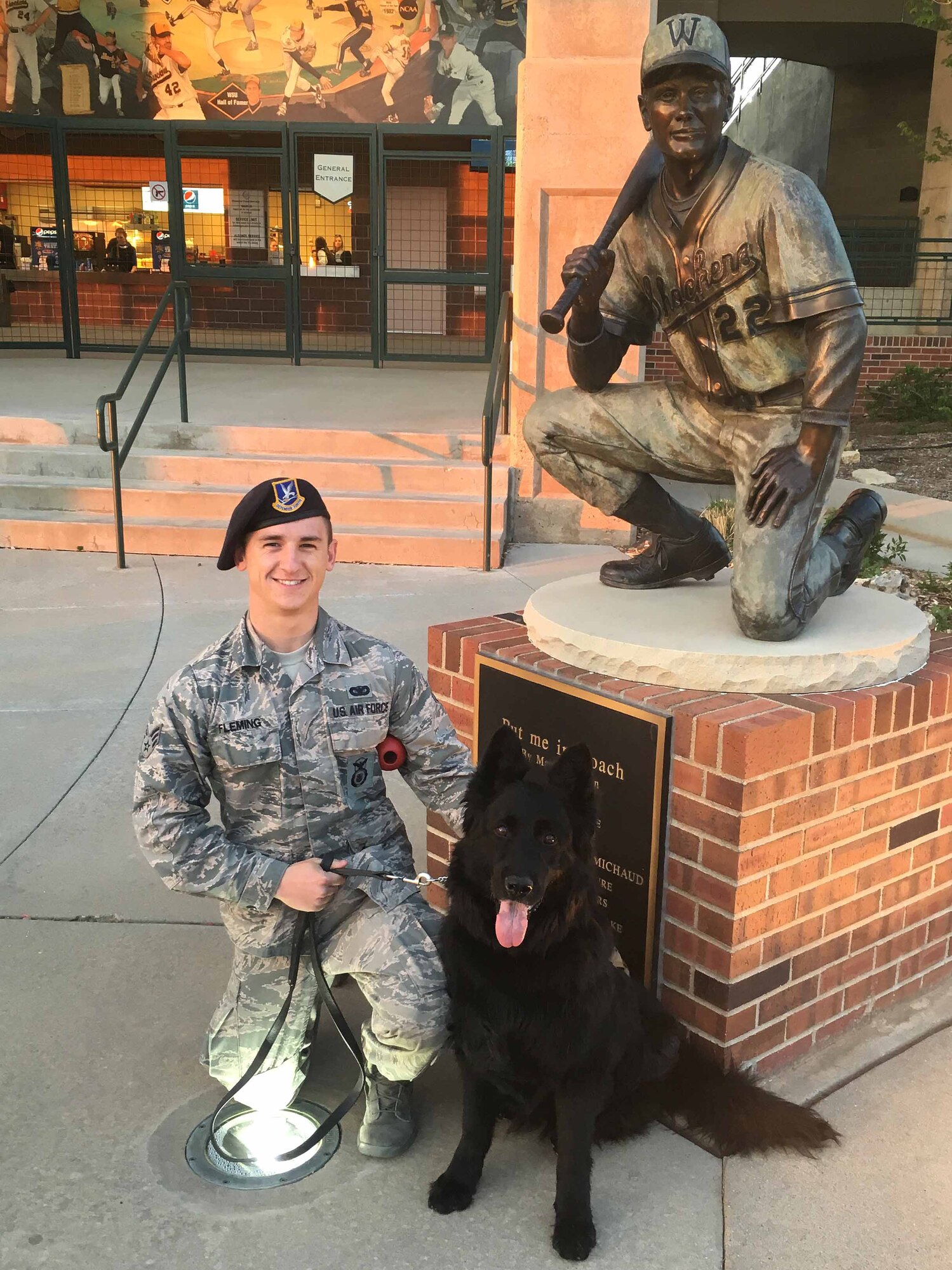 Senior Airman Michael Fleming, 22nd Security Forces Squadron military working dog handler, poses with Djule, a MWD, at a baseball game April 12, 2016, at Wichita State University in Wichita, Kan. Djule recently retired from McConnell Air Force Base after 62 dog years of service. (Courtesy photo)