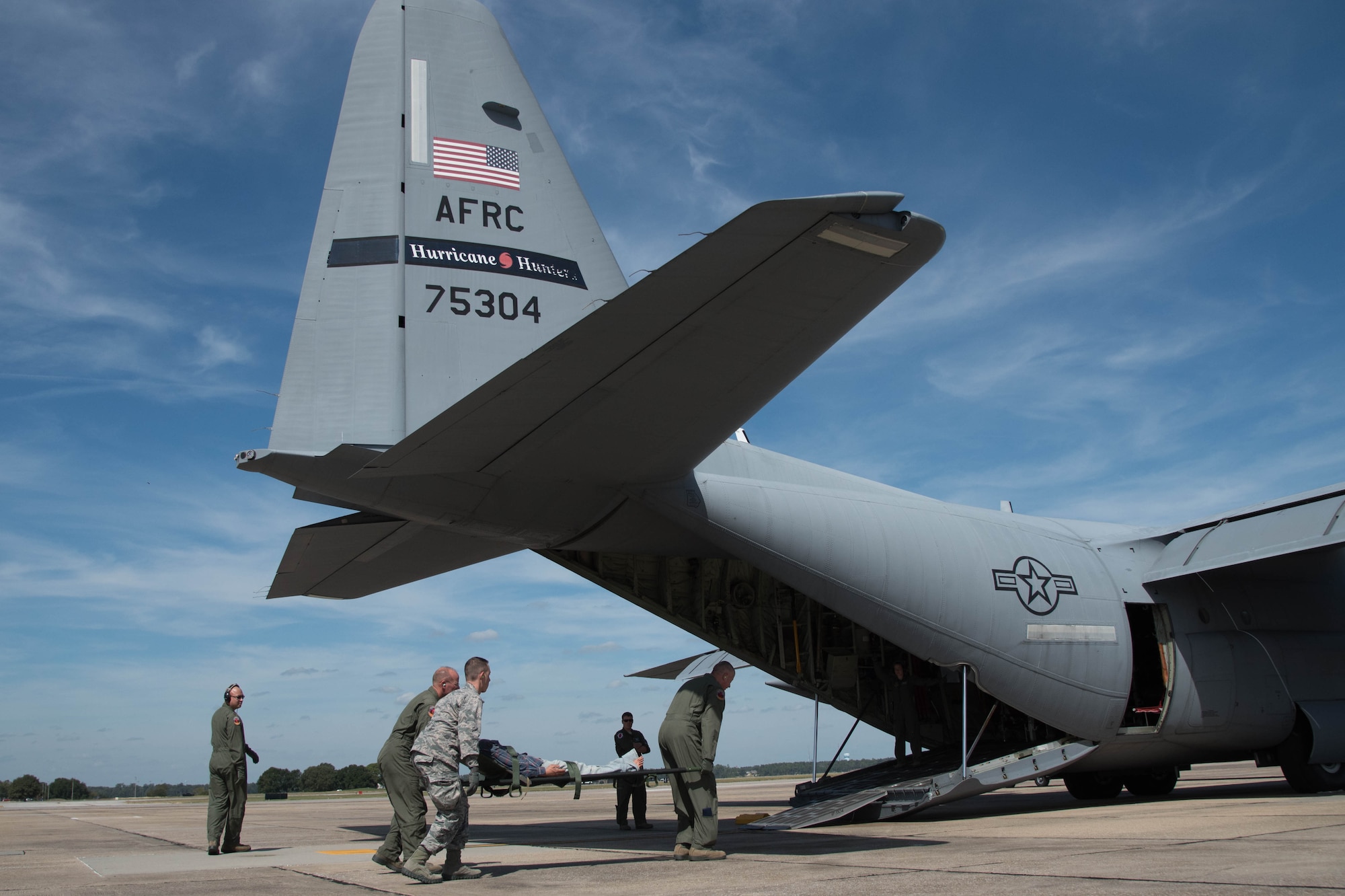 Members of the 36th Aeromedical Evacuation Squadron load a medical dummy onto a 53rd Weather Reconnaissance Squadron WC-130J Super Hercules aircraft Oct. 14 for a training mission out of Keesler Air Force Base, Miss. This mission was the units' first time sharing an aircraft for a training mission. (U.S. Air Force photo/Senior Airman Heather Heiney) 