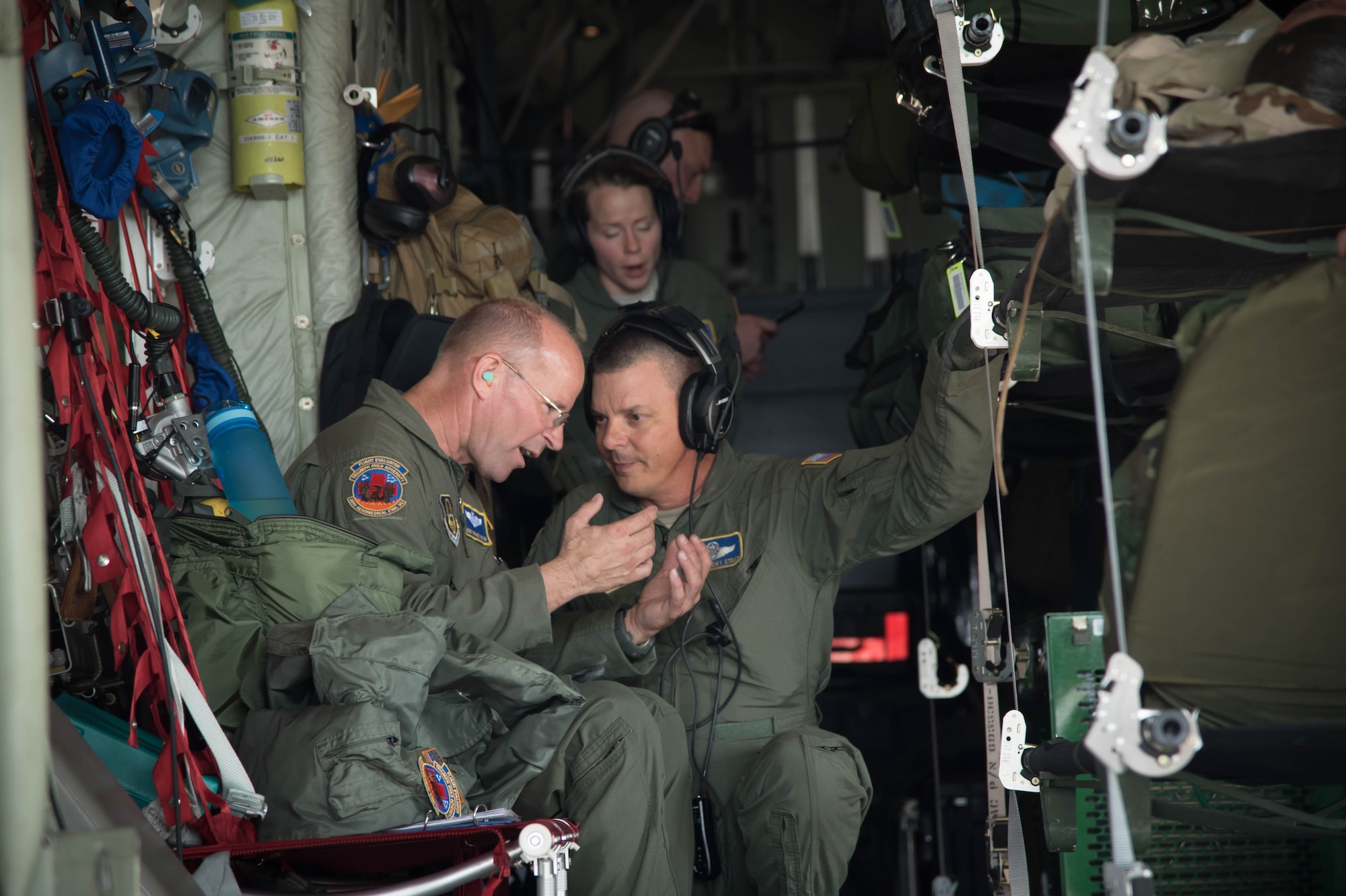 Senior Master Sgt. Michael Bolin and Senior Master Sgt. Tony Stout, 36th Aeromedical Evacuation Squadron aeromedical evacuation technicians, discuss their objectives in the back of a 53rd Weather Reconnaissance Squadron WC-130J Super Hercules aircraft Oct. 14 for a training mission out of Keesler Air Force Base, Miss. This mission was the units' first time sharing an aircraft for a training mission. (U.S. Air Force photo/Senior Airman Heather Heiney) 