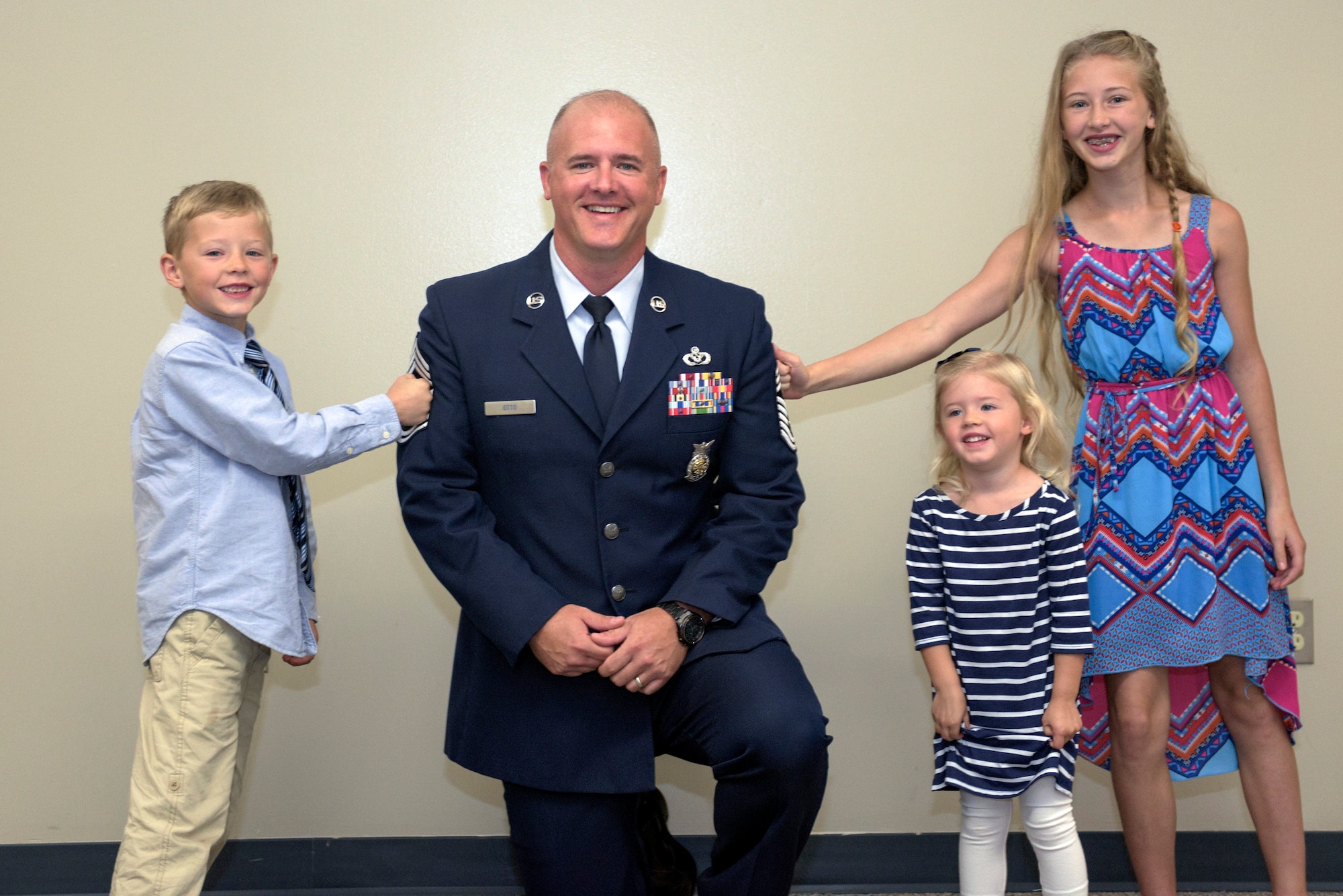 The children of U.S. Air Force Chief Master Sgt. Clifford Otto III, the fire protection chief with the 182nd Civil Engineer Squadron, Illinois Air National Guard, pin on his new stripes during his promotion ceremony at the 182nd Airlift Wing in Peoria, Ill., Oct. 1, 2016. He has 18 years of active duty and ANG military service and has served with the 182nd since 2014. (U.S. Air National Guard photo by Tech. Sgt. Lealan Buehrer)