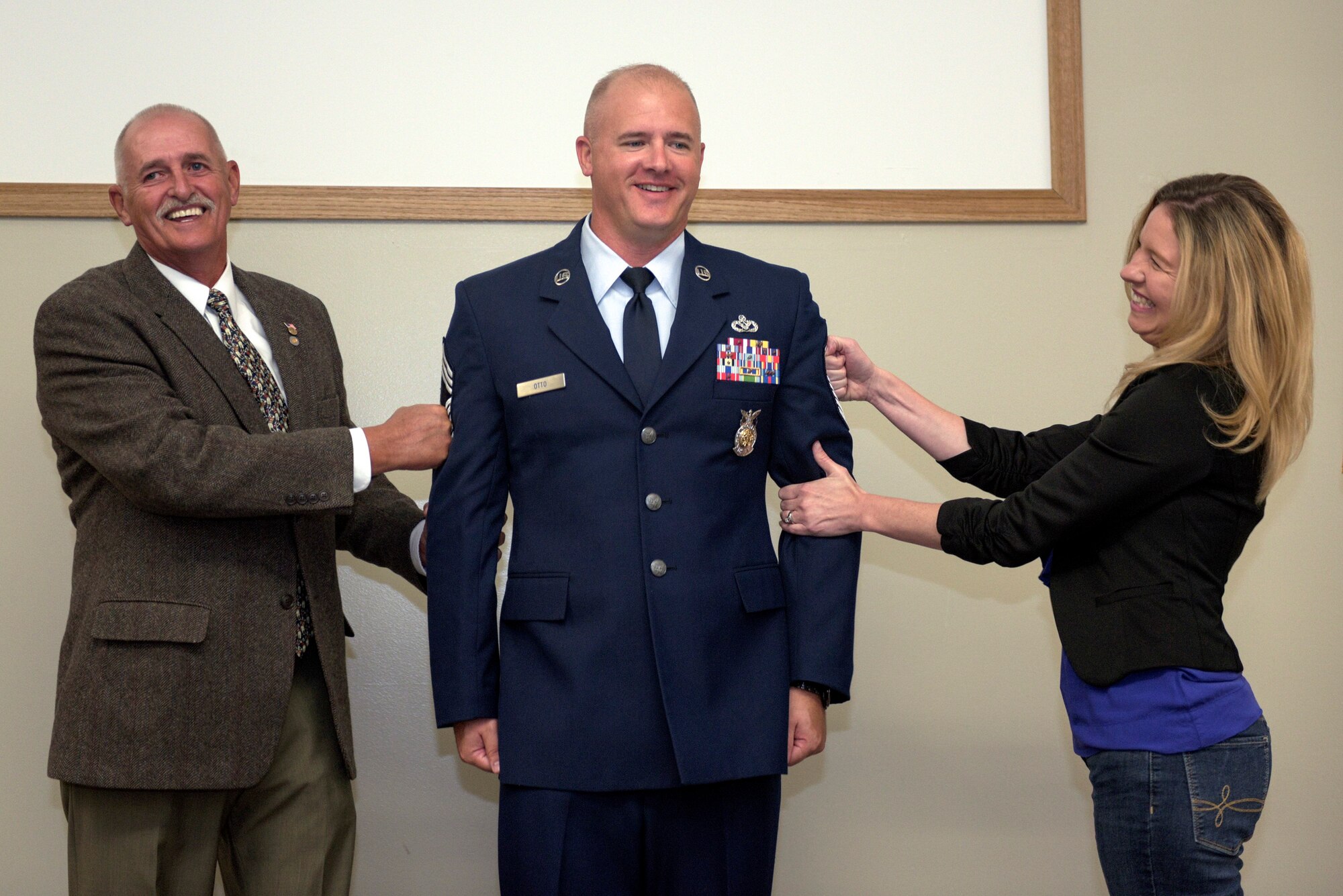 The father and spouse of U.S. Air Force Chief Master Sgt. Clifford Otto III, the fire protection chief with the 182nd Civil Engineer Squadron, Illinois Air National Guard, pin on his new stripes during Otto’s promotion ceremony at the 182nd Airlift Wing in Peoria, Ill., Oct. 1, 2016. He has 18 years of active duty and ANG military service and has served with the 182nd since 2014. (U.S. Air National Guard photo by Tech. Sgt. Lealan Buehrer)