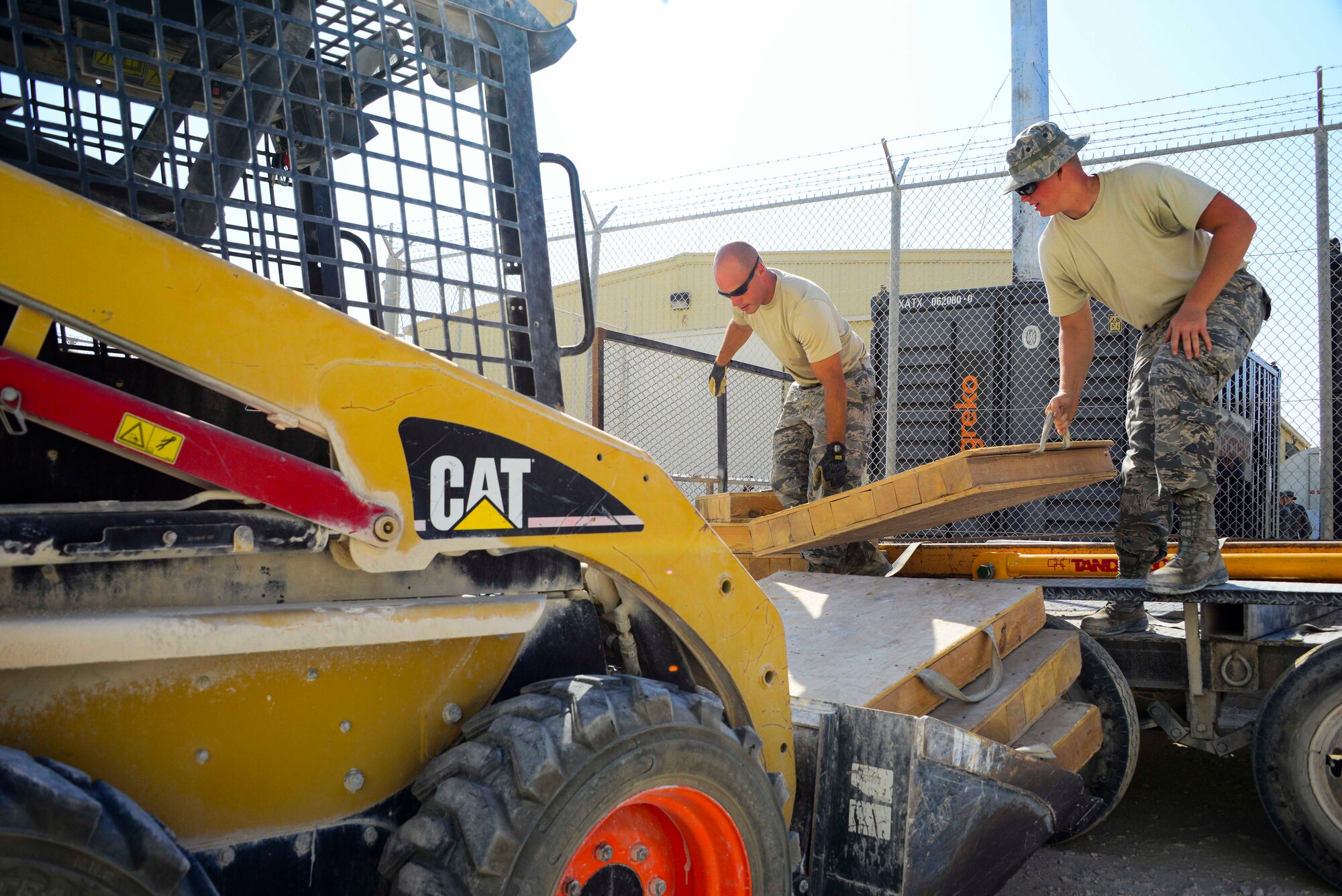 Staff Sgt. Robert Clark, 379th Expeditionary Civil Engineer Squadron pavements and equipment craftsman, and Senior Airman Ryan Batt, 379th ECES pavements and equipment specialist, load outrigger pads into a forklift truck Oct. 8, 2016, at Al Udeid Air Base, Qatar. Airmen from the 379th ECES and 379th Expeditionary Communications Squadron worked together to take down several inactive microwave dish transmissions from an area radio tower. (U.S. Air Force photo/Senior Airman Janelle Patiño/Released)