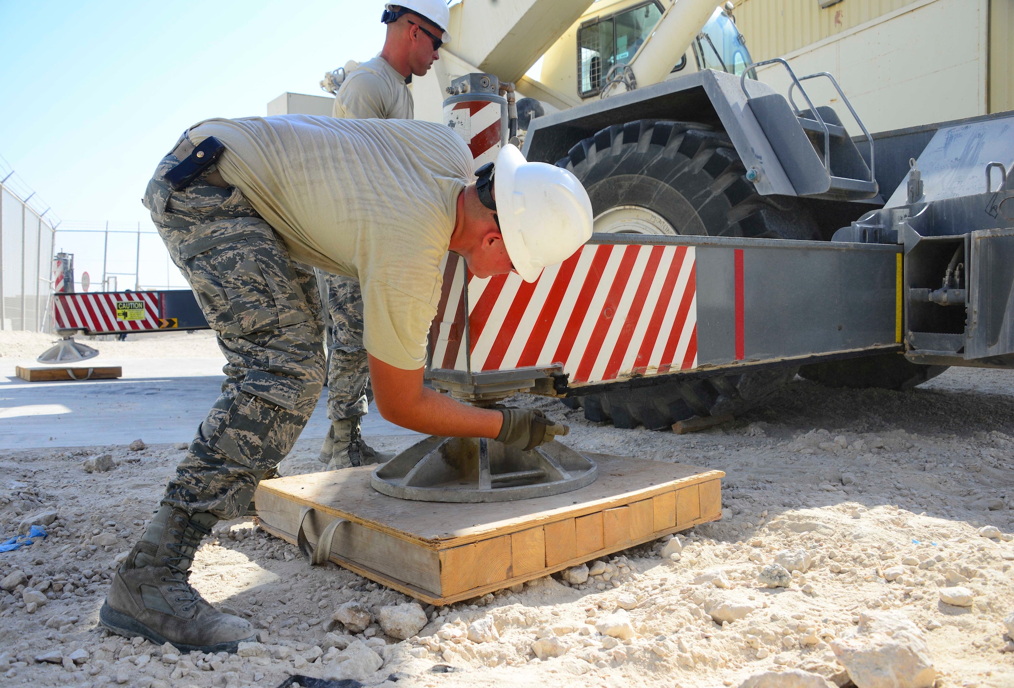 Senior Airman Ryan Batt, 379th Expeditionary Civil Engineer Squadron pavements and equipment apprentice, ensures the Terex RT 780 crane stabilizer is secured correctly Oct. 8, 2016, at Al Udeid Air Base, Qatar. Airmen from the 379th ECES and 379th Expeditionary Communications Squadron took down several inactive microwave dish transmitters from a radio tower. The transmitters previously provided internet and phone communication to the both the base and Camp As Sayliyah, but base infrastructure improvements over the years have rendered the dishes unnecessary. (U.S. Air Force photo/Senior Airman Janelle Patiño/Released)