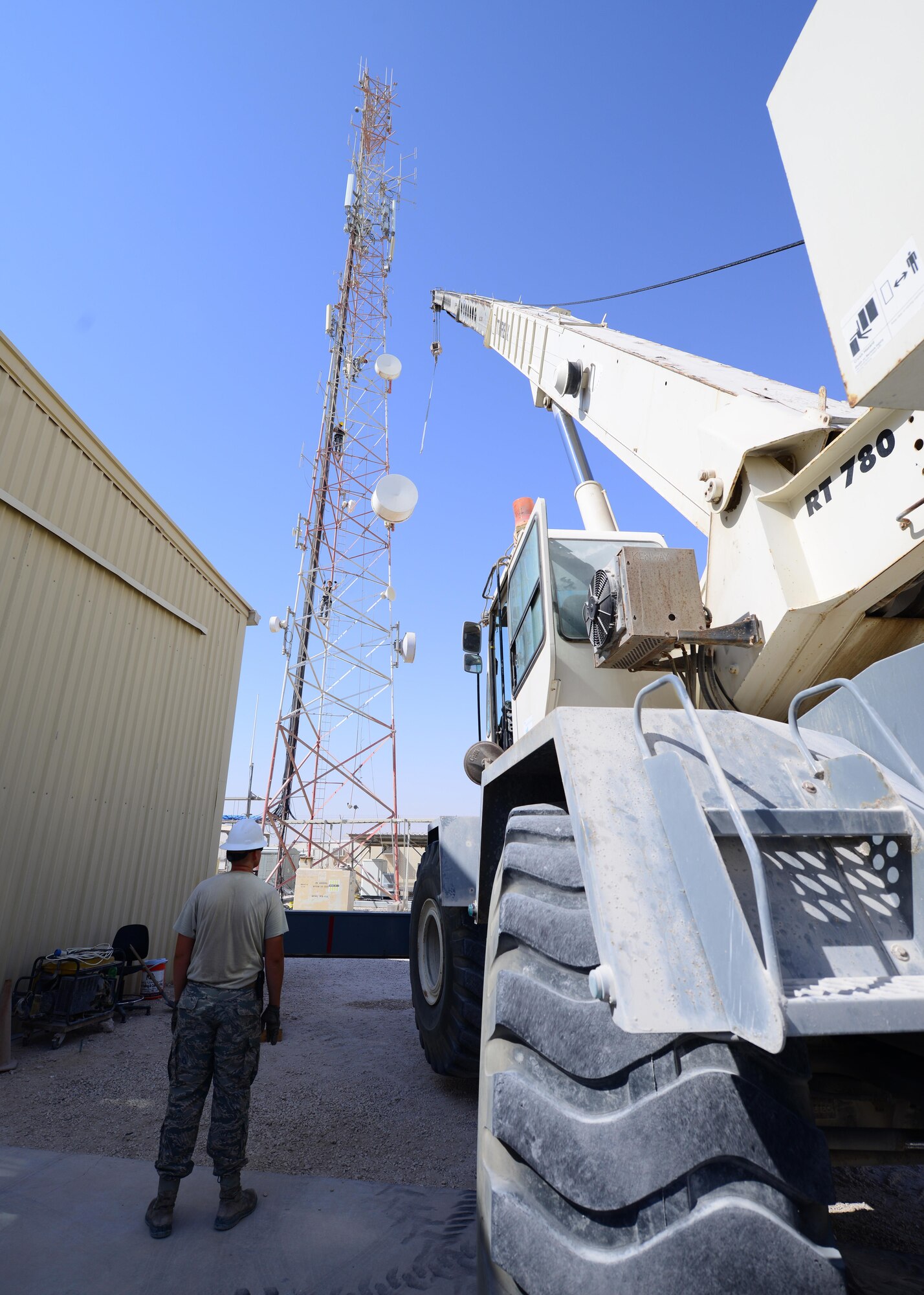 Airmen from the 379th Expeditionary Communications Squadron and 379th Expeditionary Civil Engineer Squadron work together to take down several inactive microwave dish transmitters from a radio tower Oct. 8, 2016, at Al Udeid Air Base, Qatar. The transmitters, weighing up to 200 pounds each, required the use of a Terex RT 780 crane in order to bring them down from the tower safely. (U.S Air Force photo/Senior Airman Miles Wilson/Released)
