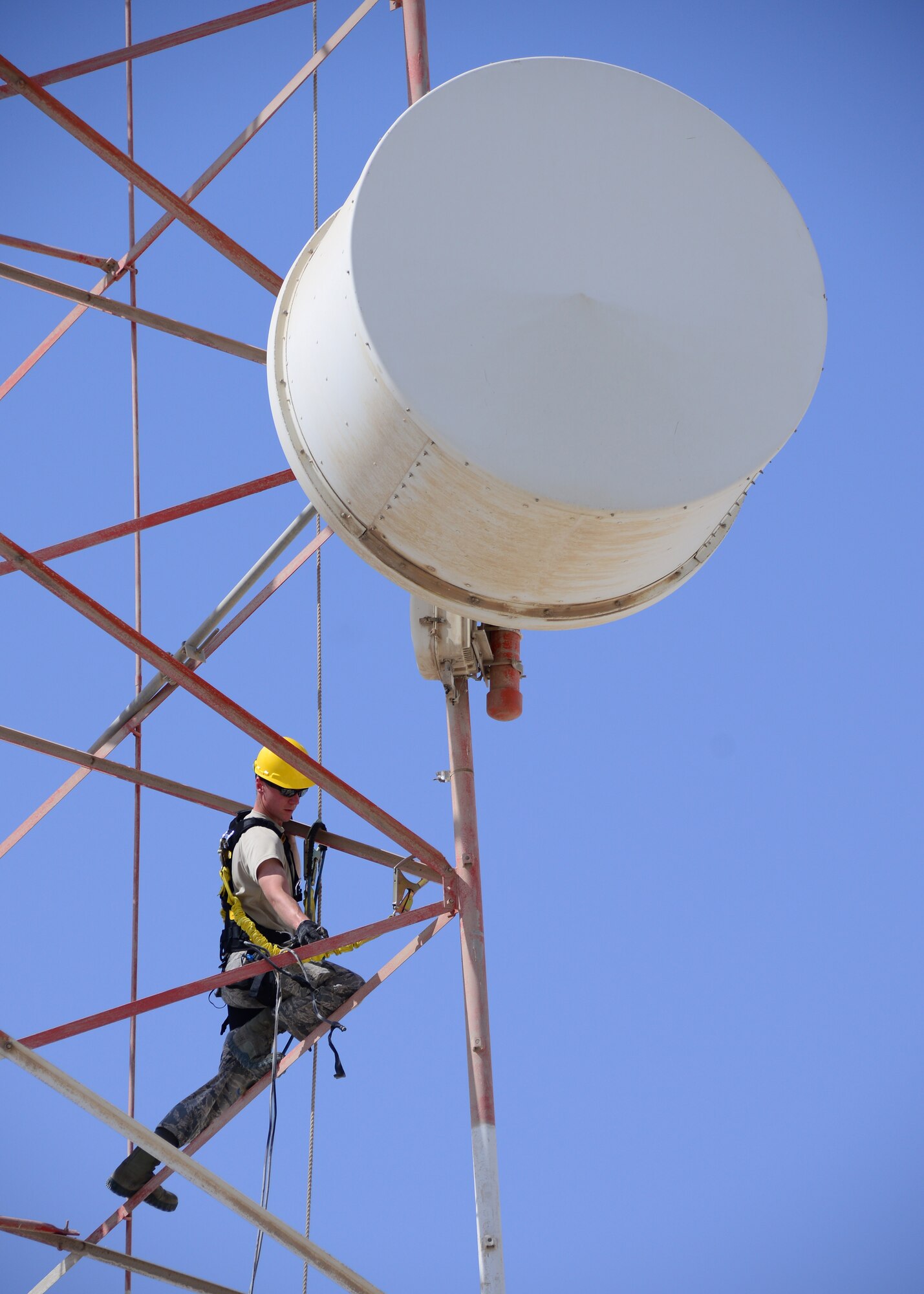 Senior Airman Benjamin Odell, 379th Expeditionary Communications Squadron radio frequency transmission journeyman, removes a microwave dish transmitter from a radio tower Oct. 8, 2016, at Al Udeid Air Base, Qatar. The transmitters were being removed due to their inactivity and their weight, which could potentially damage the structural stability of the tower itself. (U.S. Air Force Photo/Senior Airman Miles Wilson/Released)