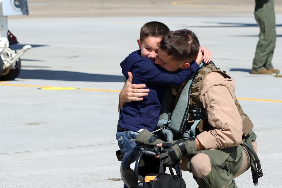 A Marine with Marine Tactical Electronic Warfare Squadron 4 embraces his son during a deployment homecoming aboard Marine Corps Air Station Cherry Point, N.C., Oct. 10, 2016. More than 20 air crew members with Marine Tactical Electronic Warfare Squadron 4 returned after a six-month deployment with the United States Central Command aboard Incirlik Air Base in Turkey. According to Lt. Col. Paul K. Johnson III, commanding officer for VMAQ-4, the Marines conducted electronic warfare and disrupted ISIS communications in Iraq and Syria in support of Operation Inherent Resolve. This deployment was the last that VMAQ-4 will participate in because the squadron is scheduled to be deactivated in the summer of 2017. (U.S. Marine Corps photo by Lance Cpl. Mackenzie Gibson/Released)