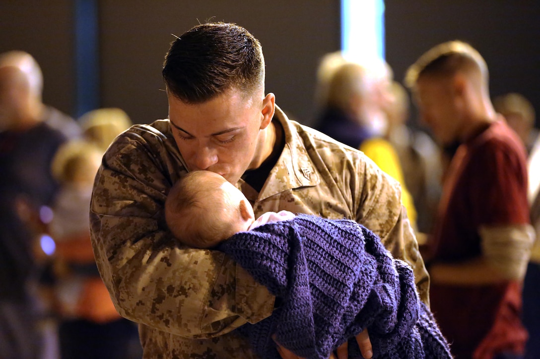 A Marine holds his son for the first time during a deployment homecoming aboard Marine Corps Air Station Cherry Point, N.C., Oct. 15, 2016. More than 120 Marines with Marine Tactical Electronic Warfare Squadron 4 returned after a six-month deployment with the United States Central Command aboard Incirlik Air Base in Turkey. According to Lt. Col. Paul K. Johnson III, commanding officer for VMAQ-4, the Marines conducted electronic warfare and disrupted ISIS communications in Iraq and Syria in support of Operation Inherent Resolve. This deployment was the last that VMAQ-4 will participate in because the squadron is scheduled to be deactivated in the summer of 2017. (U.S. Marine Corps photo by Lance Cpl. Mackenzie Gibson/Released)