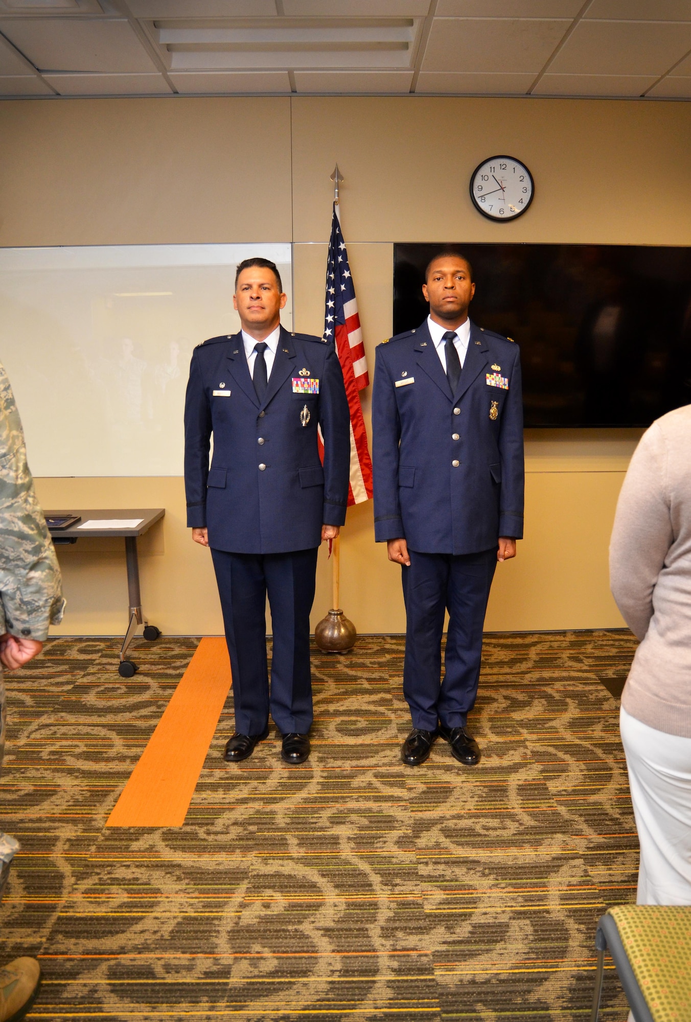 Lt. Col. Andre Wright, 94th Civil Engineer Squadron commander, and Col. Marty Hughes, 94th Mission Support Group commander, stand tall at attention during the Air Force Song. Many civil engineer Airmen came in support of Wright’s promotion. (U.S. Air Force photo by Senior Airman Lauren Douglas)