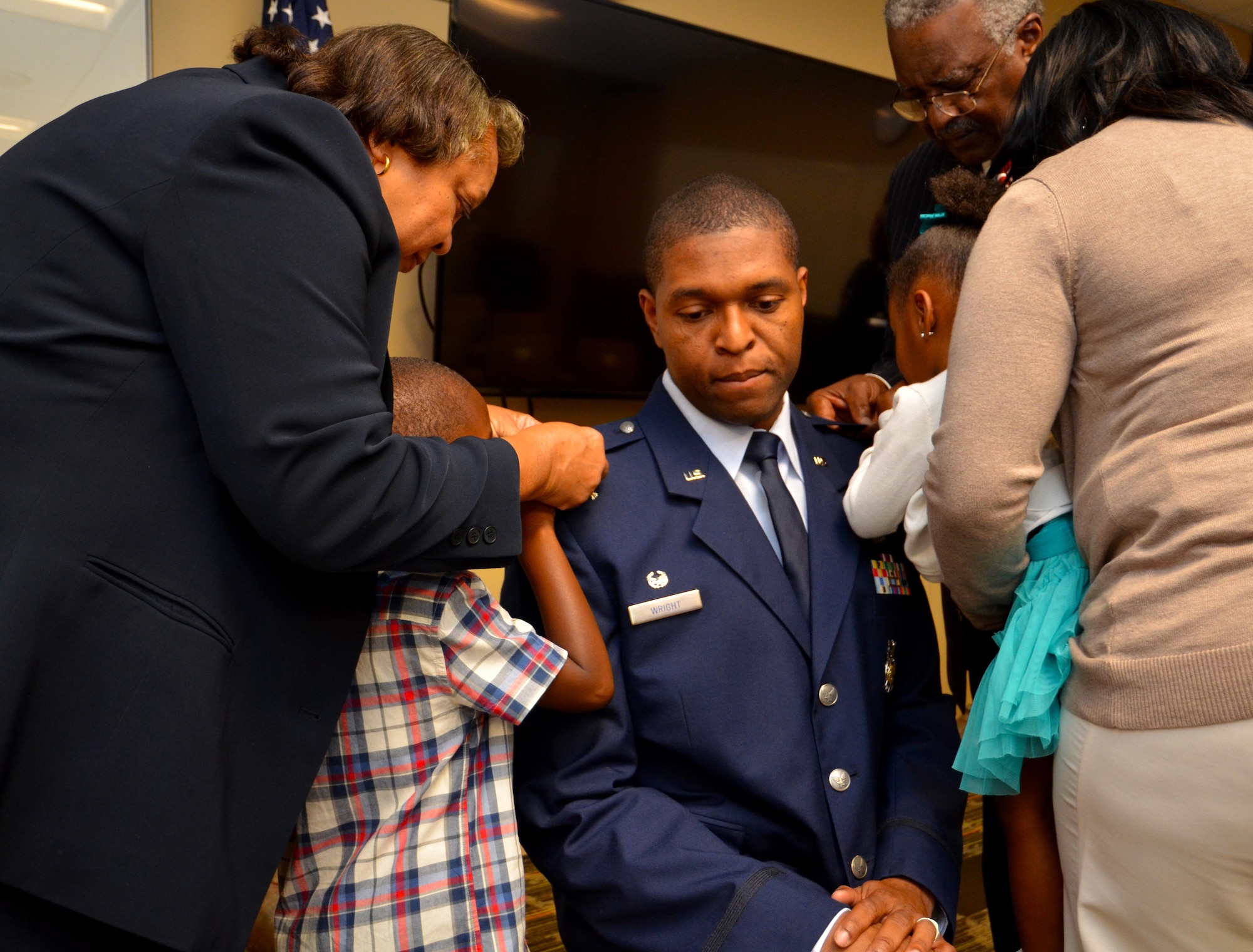 Lt. Col. Andre Wright, 94th Civil Engineer Squadron commander, is pinned by his family with his new rank during his ceremony of promotion at Dobbins Air Reserve Base on October 15, 2016. Wright spoke highly of his support system during the ceremony. (U.S. Air Force photo by Senior Airman Lauren Douglas)