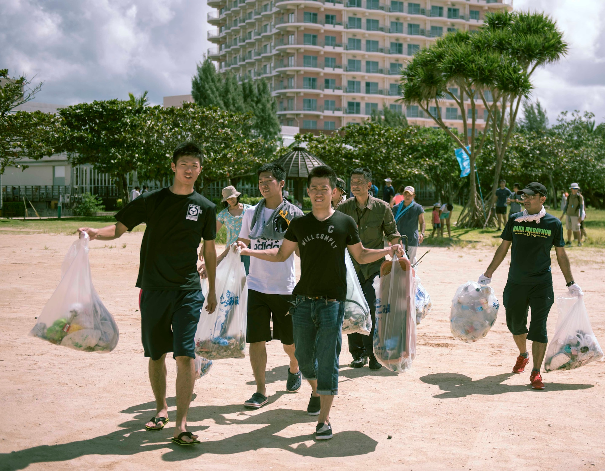 Japan Air Self-Defense Force members carry away trash collected during a beach cleanup Oct. 9, 2016, at Sunset Beach in Okinawa, Japan. Volunteers from Kadena and Naha Air Bases came together to build partnership and relations during the event. (U.S. Air Force photo by Senior Airman Omari Bernard)