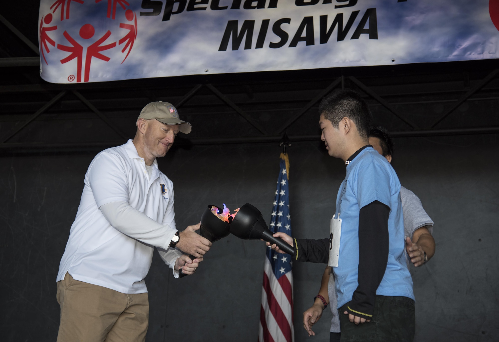 Col. Travis Rex, left, the 35th Fighter Wing vice commander, and Teruaki Kikuchi, right, a Special Olympics athlete from Rikuzentakata City, Japan, performs a torch lighting ceremony at Misawa Air Base, Japan, Oct. 15, 2016. The ceremony symbolizes the start of the Olympic Games and derives from ancient Greece. (U.S. Air Force photo by Airman 1st Class Sadie Colbert)