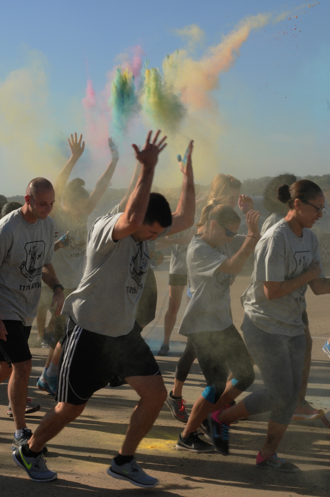 Military members participating in the 111th Attack Wing Military Color Fun Run toss handfuls of colored powder into the air during the start of the event at Horsham Air Guard Station, Pa., Oct. 15, 2016. The event, a first for the 111th ATKW, was developed and directed by the services flight of the 111th Force Support Squadron. (U.S. Air National Guard photo by Senior Airman Timi Jones)
