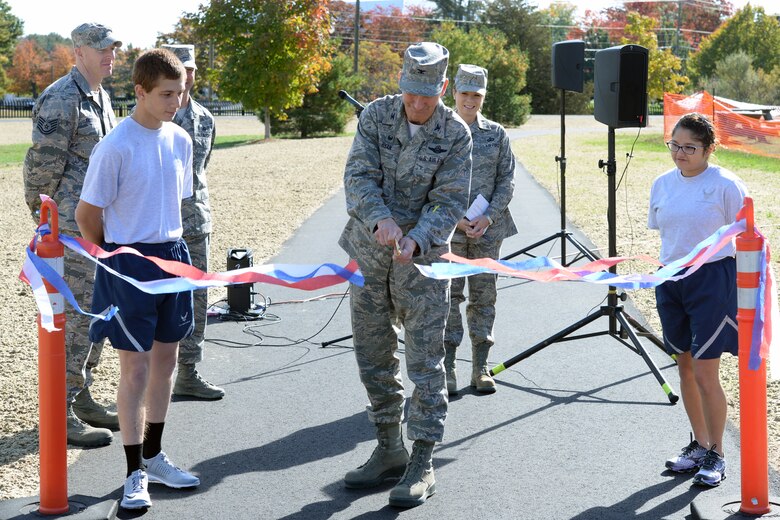 U.S. Air Force Col. James Ryan, Commander, 157th Air Refueling Wing, New Hampshire Air National Guard, cuts the ribbon during the grand opening of a new running track, Pease Air National Guard Base, N.H. Oct. 15, 2016. The purpose of the new track is to give Airmen a safe, dedicated space for running in preparation for and execution of fitness tests, as well as to enhance personal physical fitness.  (U.S. Air National Guard photo by Staff Sgt. Curtis J. Lenz)