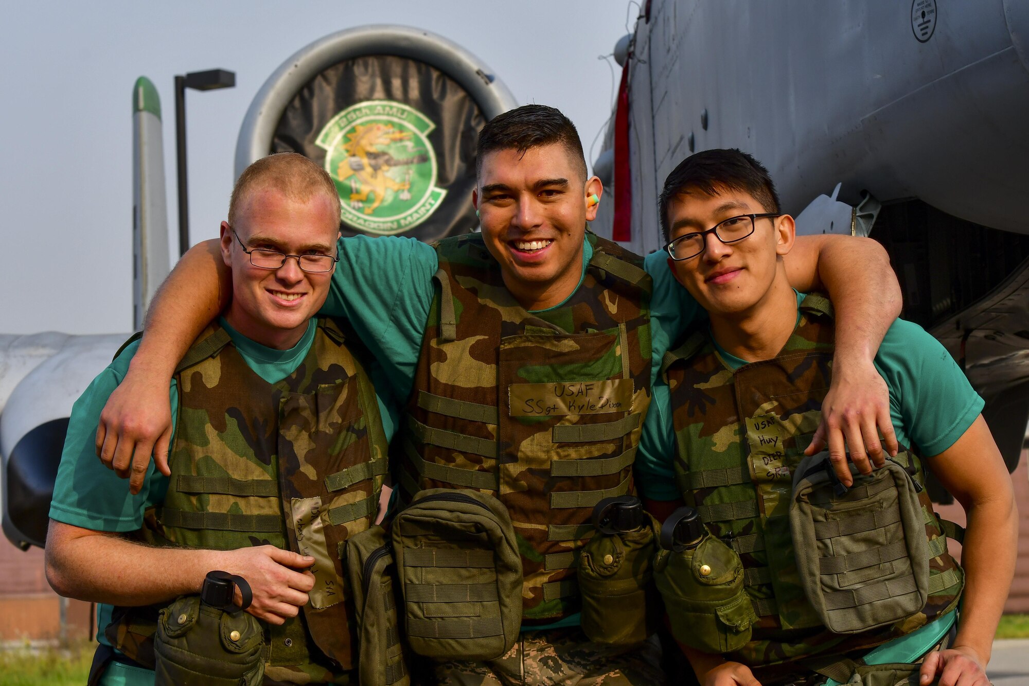 U.S. Air Force Staff Sgt. Kyle Dixon, 25th Aircraft Maintenance Unit weapons load crew lead, middle, poses with Senior Airmen Zachery Wright, left, and Huy Diep, right, 25th AMU weapons load crew members, at Osan Air Base, Republic of Korea, Oct. 14, 2015. The three Airmen had just finished competing in the 51st Maintenance Group’s Weapons Load Crew of the Quarter competition against the 36th AMU. (U.S. Air Force photo by Senior Airman Victor J. Caputo)