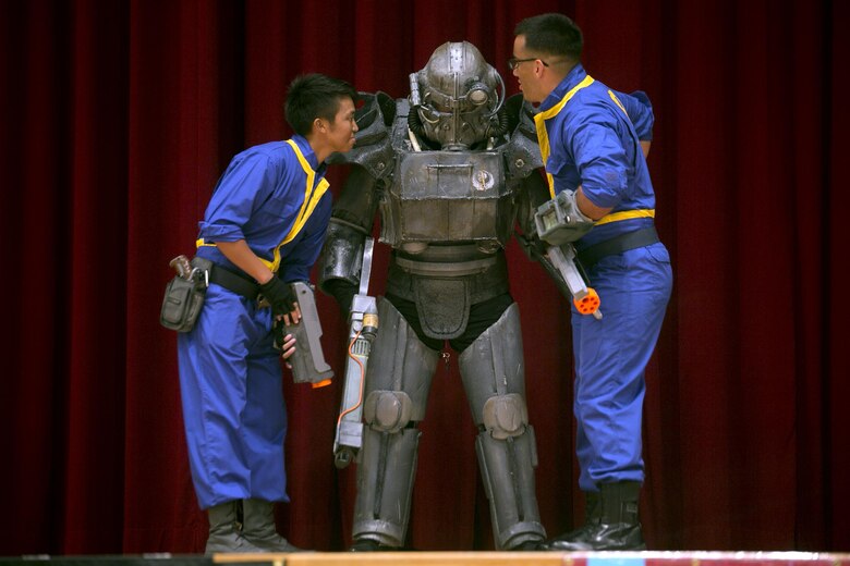 Cpl. Ryanne Cando, left, Senior Airman Daniel Kim, center, and Cpl. Oscar Rodriguez perform their skit October 15 during the cosplay contest at Comic Con on Camp Foster, Okinawa, Japan. More than 25 attendees participated in the cosplay contest dressed as characters from video games, comic books and movies. Cando, Kim and Rodriguez won the group cosplay contest dressed as characters from the video game series Fallout. The free event was open for attendance to Status of Forces Agreement members and the local Okinawa community. Cando, a Gaithersburg, Maryland native and Rodriguez, a Chicago, Illinois native, are radio operators with 1st Battalion, 12th Marine Regiment, 3rd Marine Division, III Marine Expeditionary Force. Kim, a New York City native, is with 18th Security Forces Squadron on Kadena Airbase.  (U.S. Marine Corps photo by Cpl. Brittany A. James / Released)