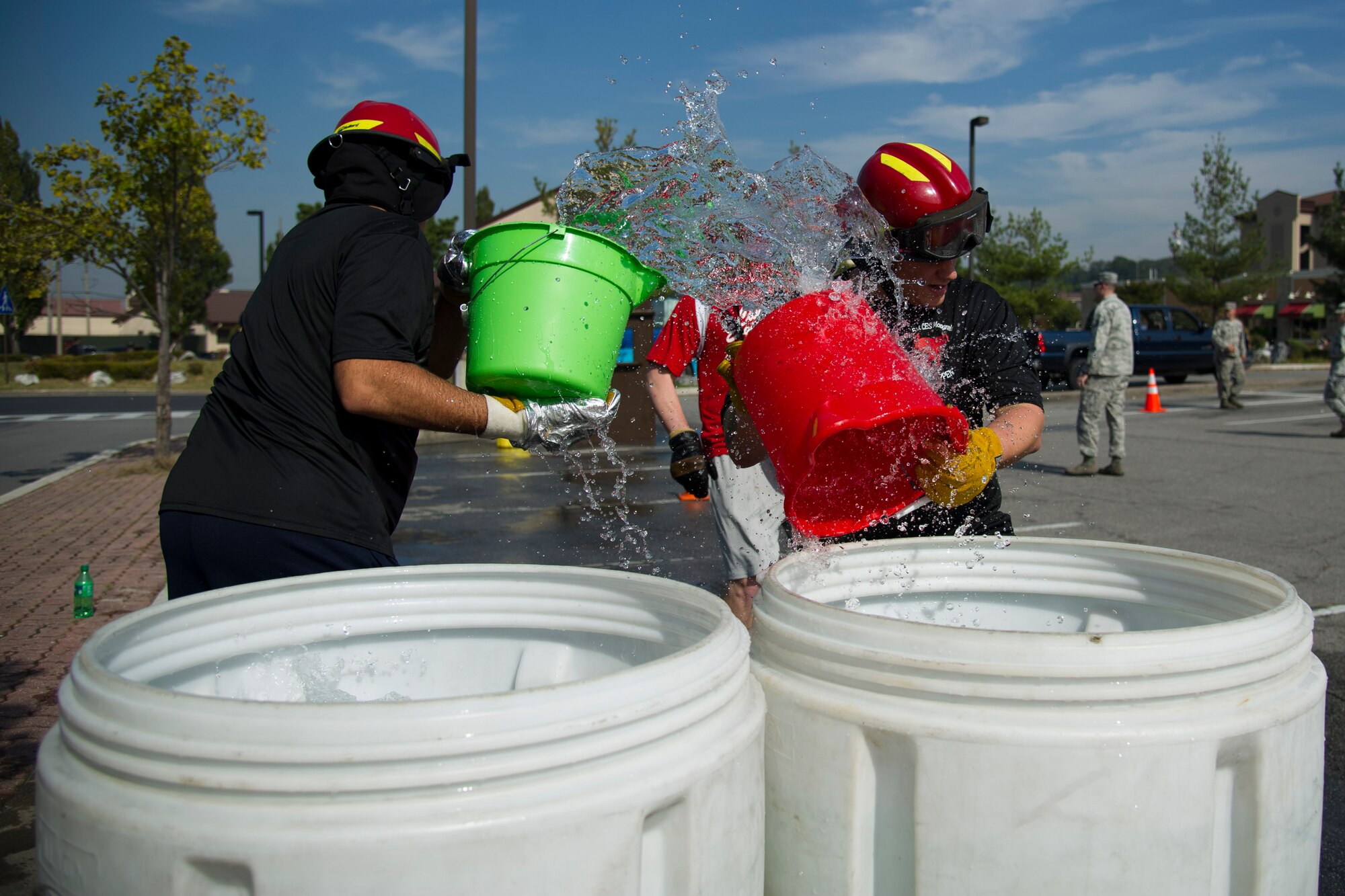 A team from 51st Civil Engineer Squadron emergency management grabs buckets of water for a relay race during Fire Muster 2016 on Osan Air Base, Republic of Korea, Oct. 13, 2016.  Osan’s firefighters organized the fire muster to bring awareness to Osan for Fire Prevention Week Oct. 9-15. The fire muster had six stations for the four-person team run-through. (U.S. Air Force photo by Staff Sgt. Jonathan Steffen) 