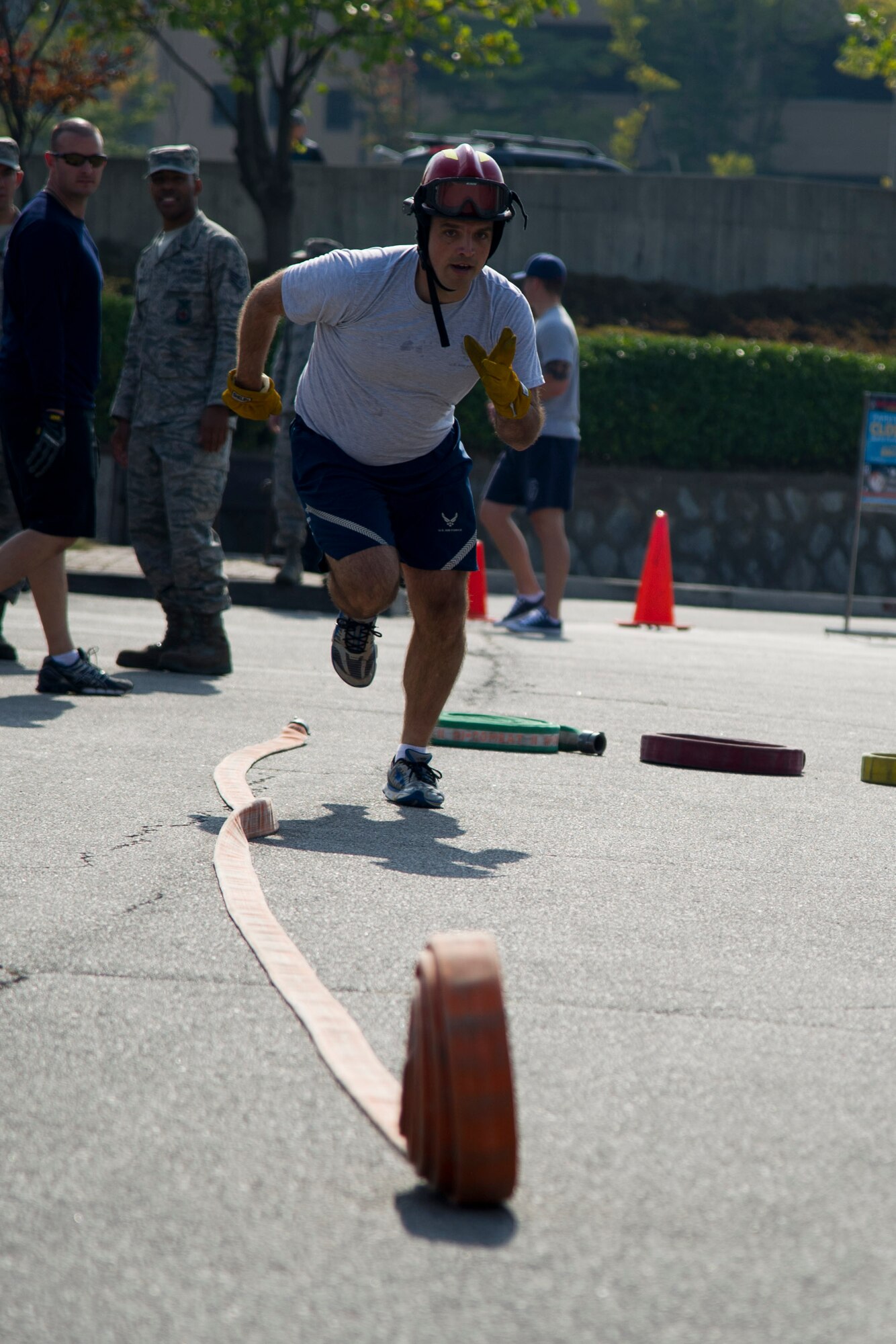 U.S. Air Force Lt. Col. Andrew Sheehan, 51st Civil Engineer Squadron commander, rolls out a hose during Fire Muster 2016 on Osan Air Base, Republic of Korea, Oct. 13, 2016.  Osan’s firefighters organized the fire muster to bring awareness to Osan for Fire Prevention Week Oct. 9-15. The Fire Prevention Week theme this year is “Don’t wait, check the date” reminding everyone to replace smoke alarms every ten years.  (U.S. Air Force photo by Staff Sgt. Jonathan Steffen) 