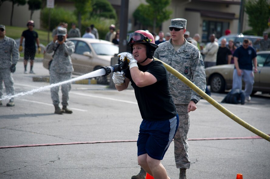 U.S. Air Force Staff Sgt. Justin Jordan, 51st Security Forces Squadron military working dog trainer, sprays a fire hose during Fire Muster 2016 on Osan Air Base, Republic of Korea, Oct. 13, 2016.  Osan’s firefighters organized the fire muster to bring awareness to Osan for Fire Prevention Week Oct. 9-15.  Fire Prevention Week theme this year is “Don’t wait, check the date” reminding everyone to replace smoke alarms every 10 years. (U.S. Air Force photo by Staff Sgt. Jonathan Steffen) 