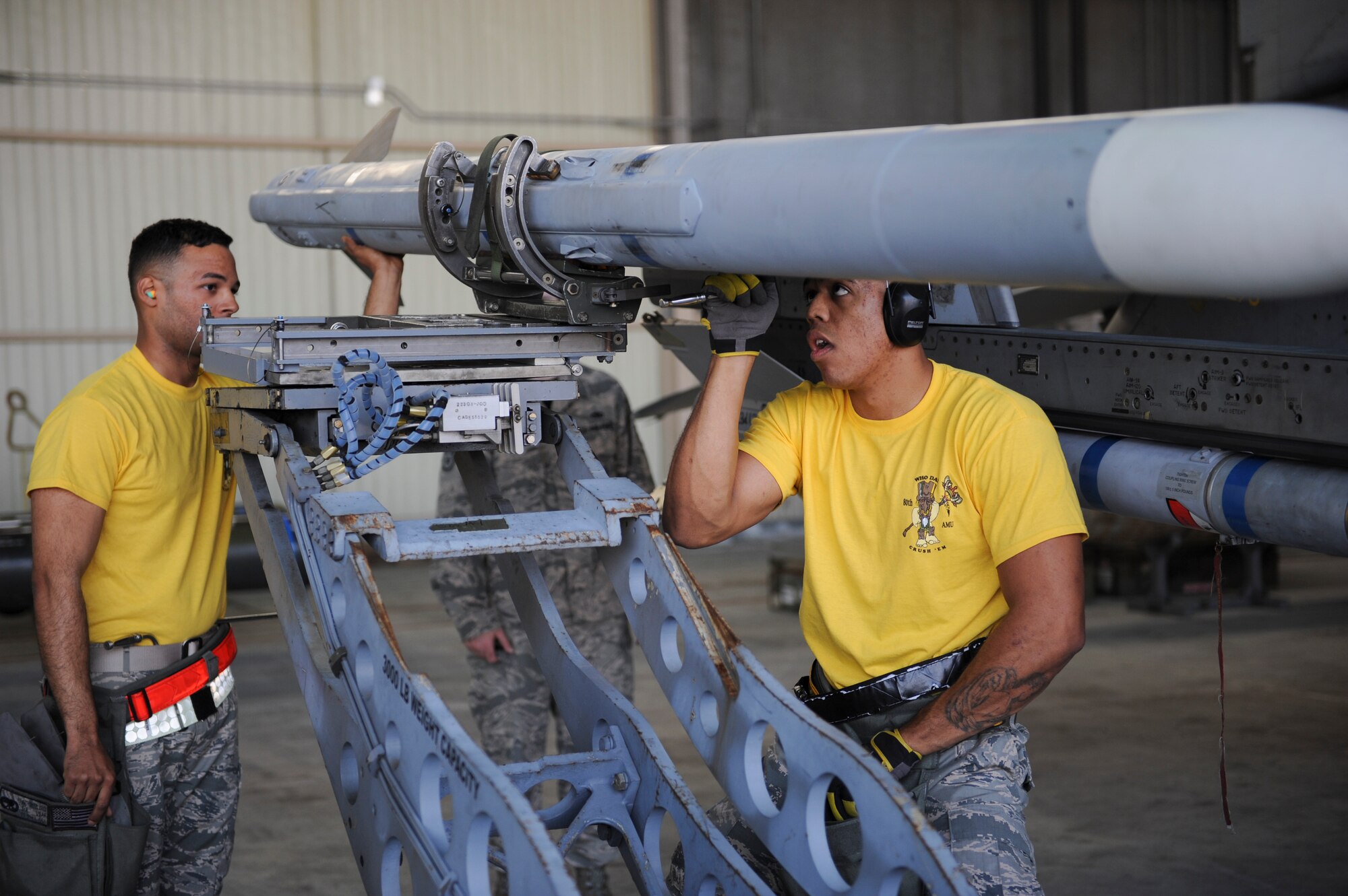Senior Airman Anthony Beaz, left, and Staff Sgt. Dwight Hunter, 80th Aircraft Maintenance Unit load crew members, secure an inert munition during the Weapons Load Crew of the Quarter competition at Kunsan Air Base, Republic of Korea, Oct. 14, 2016. The event consisted of members from the 38th Logistics Squadron, 80th AMU and 35th AMU competing in a timed munitions load. This was the first year the ROK Air Force and U.S. Air Force participated in the event together. (U.S. Air Force photo by Senior Airman Michael Hunsaker/Released)