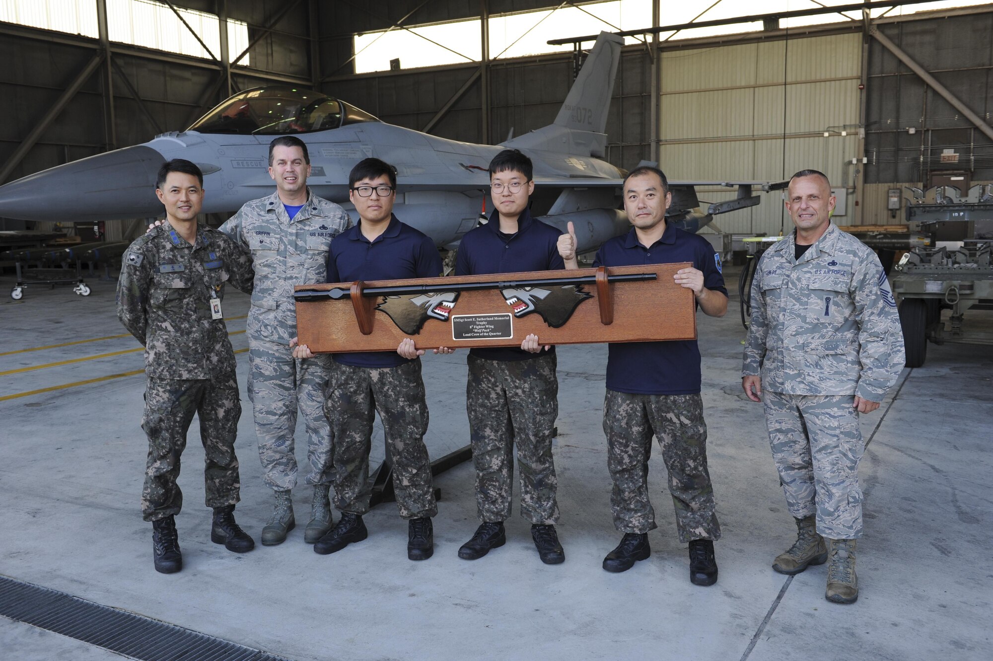 Load crew members from the 38th Logistics Squadron accept a trophy during the Weapons Load Crew of the Quarter competition at Kunsan Air Base, Republic of Korea, Oct. 14, 2016. The event consisted of members from the 38th Logistics Squadron, 80th AMU and 35th AMU competing in a timed munitions load. This was the first year the ROK Air Force and U.S. Air Force participated in the event together. (U.S. Air Force photo by Senior Airman Michael Hunsaker/Released)