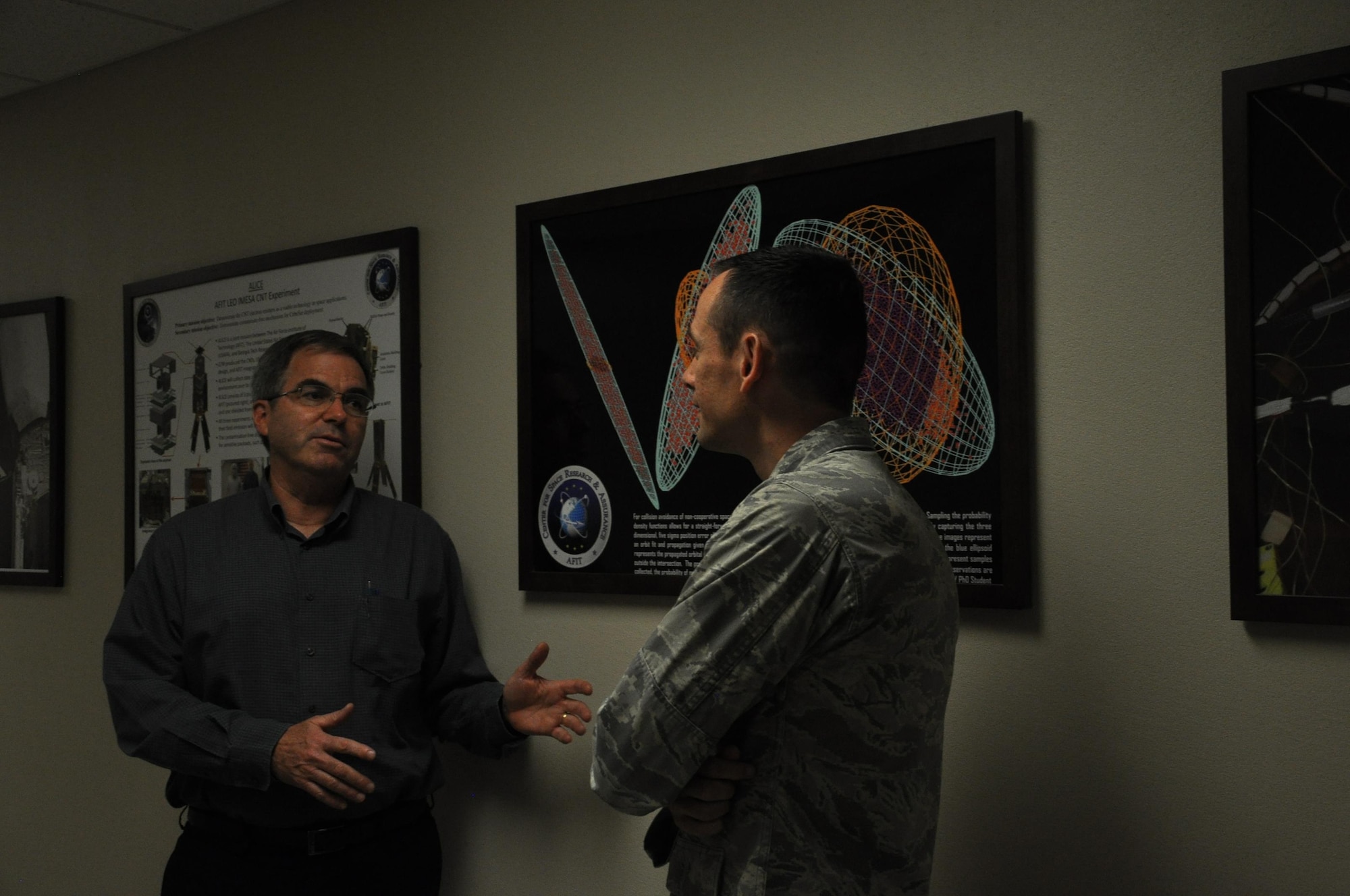 Dr. Richard Cobb, Professor, Aeronautics and Astronautics, and Maj. Ryan Carr, Ph.D. student, discuss aerodynamics.(U.S. Air Force photo/Sandy Simison)