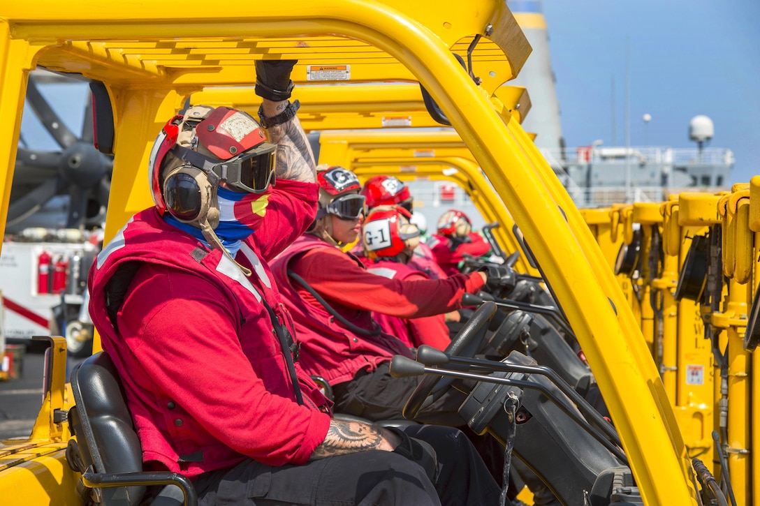 Navy Seaman Hunter McGuinnis, foreground, waits to receive supplies on the flight deck of the aircraft carrier USS Dwight D. Eisenhower during a replenishment-at-sea with the fleet replenishment oiler USNS Pecos in the Persian Gulf, Oct. 14, 2016. McGuinnis is an aviation ordnanceman. Navy photo by Petty Officer 3rd Class Robert J. Baldock