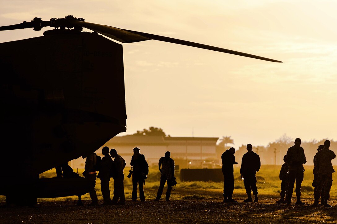 U.S. troops and Associated Press photographers board an Army CH-47 Chinook helicopter to participate in a U.S. Agency for International Development humanitarian mission in Port-au-Prince, Haiti, Oct. 14, 2016. The troops are assigned to Joint Task Force Matthew, which includes multinational partners providing aid to those in need in Haiti.  Air Force photo by Staff Sgt. Paul Labbe