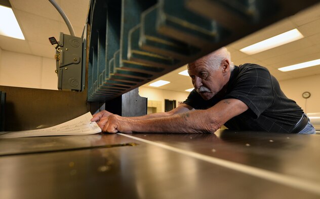 Joe Knott, an electronic duplicating systems technician with Defense Logistic Agencies Document Services, prepares to cut a ream of paper with a Challenger 370C cutter inside of the document services print shop located in the Martin Bomber Building on Oct. 6, Offutt Air Force Base, Neb.  Joe has been working within the print shop since he was hired in 1979.  