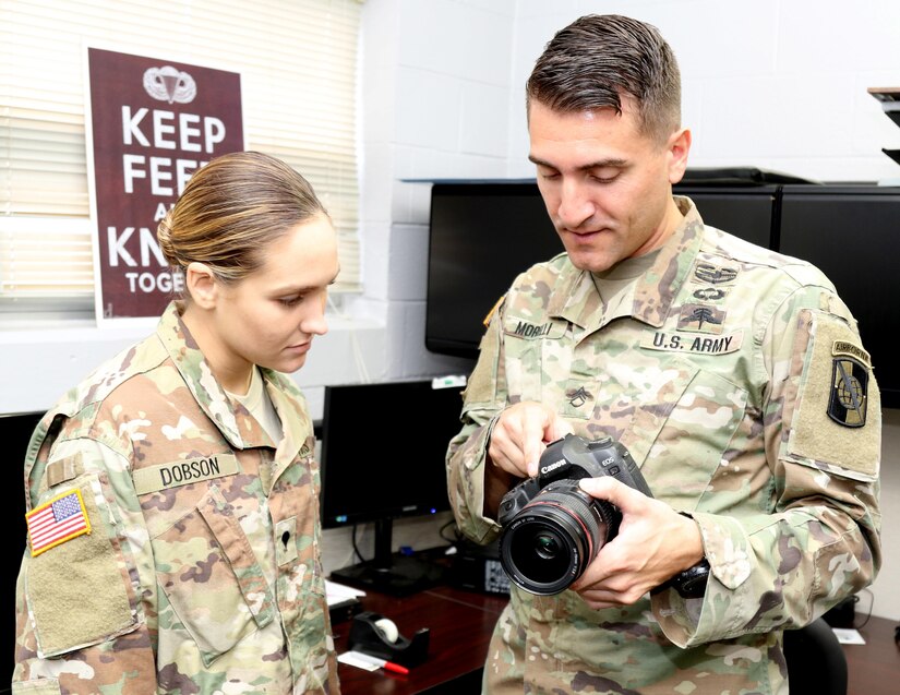 Army Reserve Staff Sgt. Justin P. Morelli, a combat cameraman and the noncommissioned officer-in-charge of training, assigned to the 982nd Combat Camera Company, 335th Signal Command (Theater), discusses various camera functions with Spc. Kristen A. Dobson, a combat cameraman and native of Douglasville, Georgia, also assigned to the 982nd at the unit headquarters in East Point, Georgia.  Morelli recently completed the four-week Free fall Parachutist course in Yuma, Arizona, becoming the first Army Reserve combat cameraman to do so.