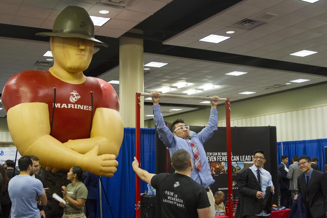 Marines watch students conduct pull ups during the career fair at the 2016 Society of Asian Scientists and Engineers National Convention in Dallas, Texas Oct 15. The presence of the Marine Corps at SASE creates a positive reminder to those participating that Marines are supportive of SASE as an organization, its efforts and the communities it represents.