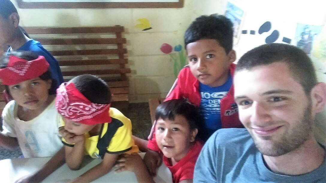 Pfc. Joshua Anderson, an Army Reserve service desk technician at the 335th Signal Command (Theater) headquarters, and a native of Woodstock, Georgia, poses with children in Siguatepeque, Honduras during a recent volunteer mission.  Anderson and a group of volunteers from his church hosted English classes for children, and conducted various refurbishing and beautification projects at a seminary there.