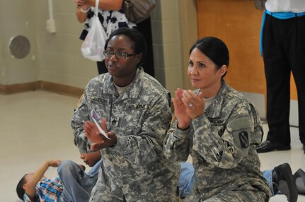 Army Reserve Soldiers Staff Sgt. Elizabeth Abidoye and Sgt. 1st Class Jasmine Pruitt, assigned to the 359th Theater Tactical Signal Brigade, 335th Signal Command (Theater), applaud during a performance by the Sion Dancers Sept. 18 at Fort Gordon, Georgia. Pruitt, the senior equal opportunity advisor for the 359th TTSB, helped orchestrate the dance troup's visit to the unit as a part of the Hispanic Heritage Month observance. (Official U.S. Army Reserve photo by Sgt. Anthony J. Hooker, 359th TTSB public affairs)