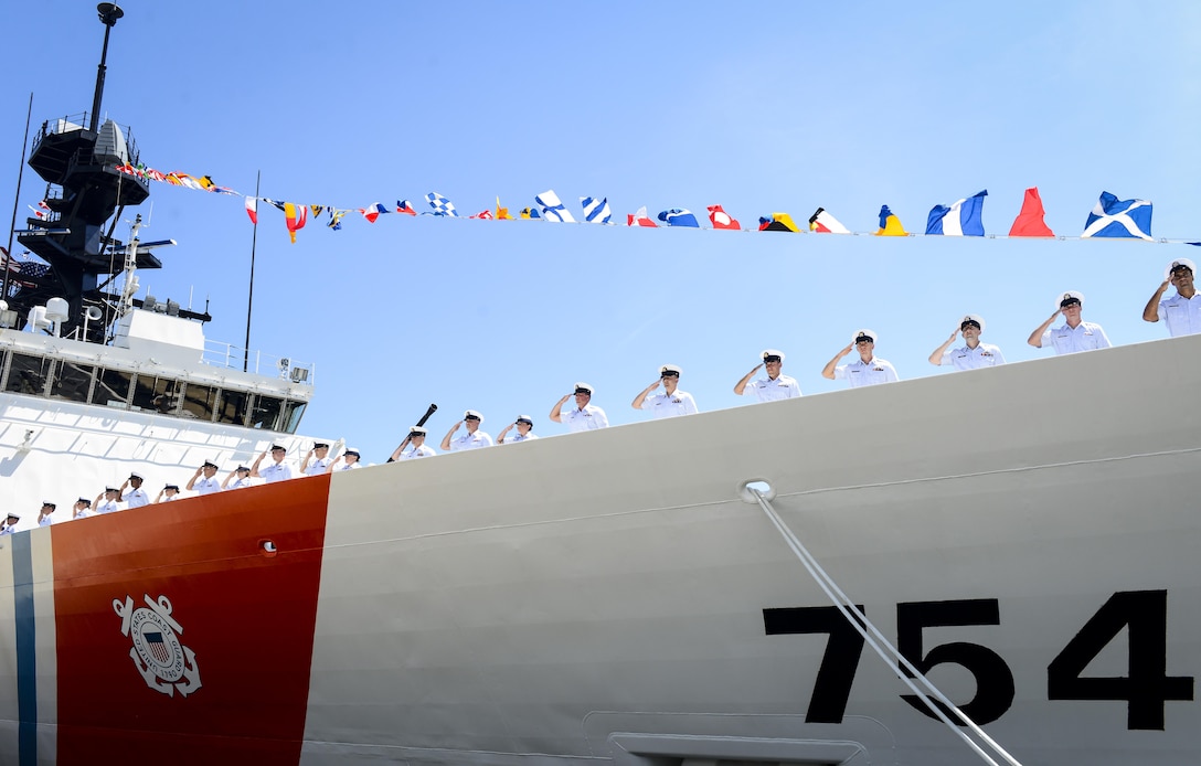 The Coast Guard commissioned its newest National Security Cutter, the 418-foot Coast Guard Cutter James, during a ceremony at Coast Guard Base Boston Aug. 8, 2015. Here, the crew of the James renders a hand salute during the blowing of the ship's whistles. (U.S. Coast Guard photo by Petty Officer 3rd Class Ross Ruddell)